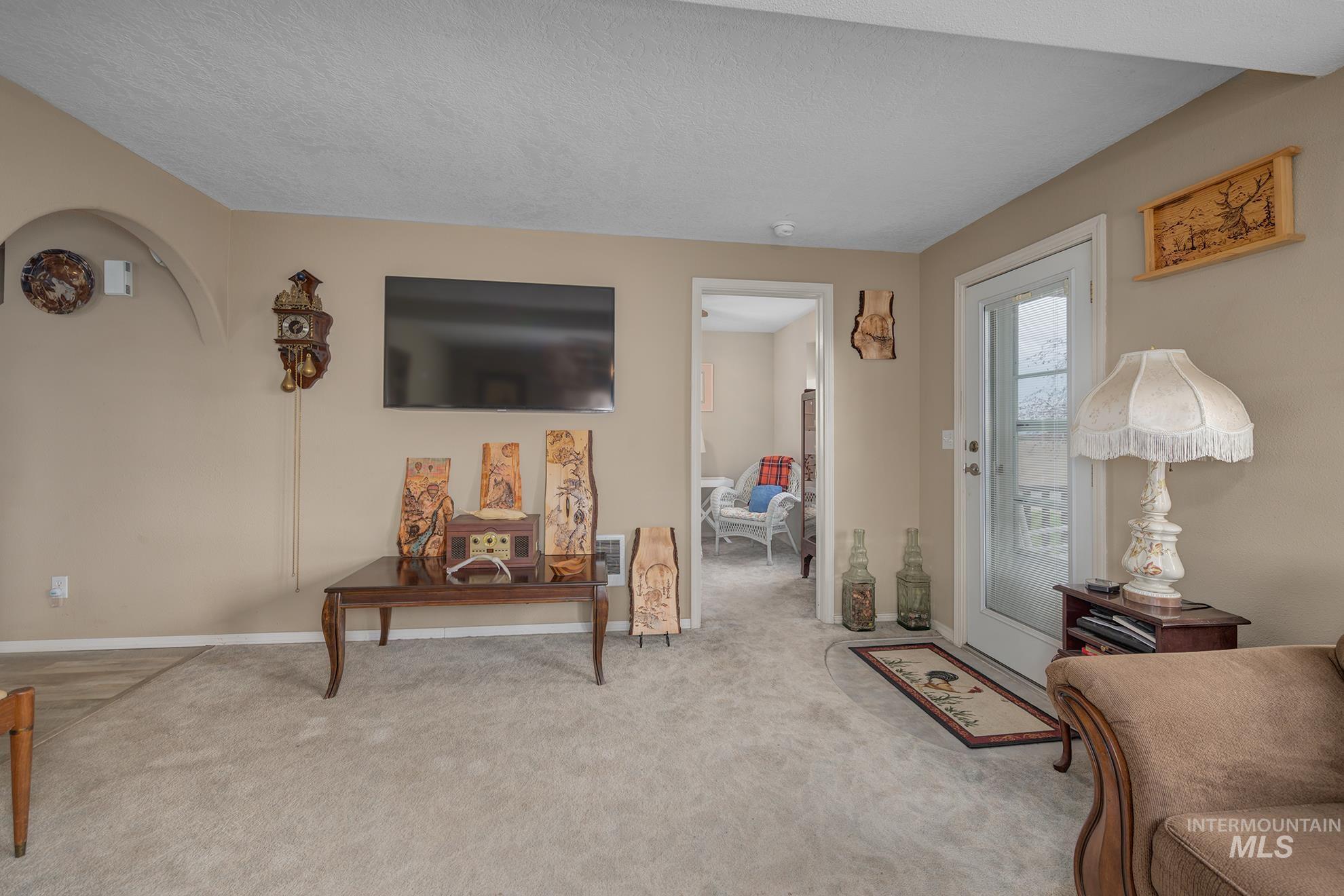 Living area with carpet floors and a textured ceiling