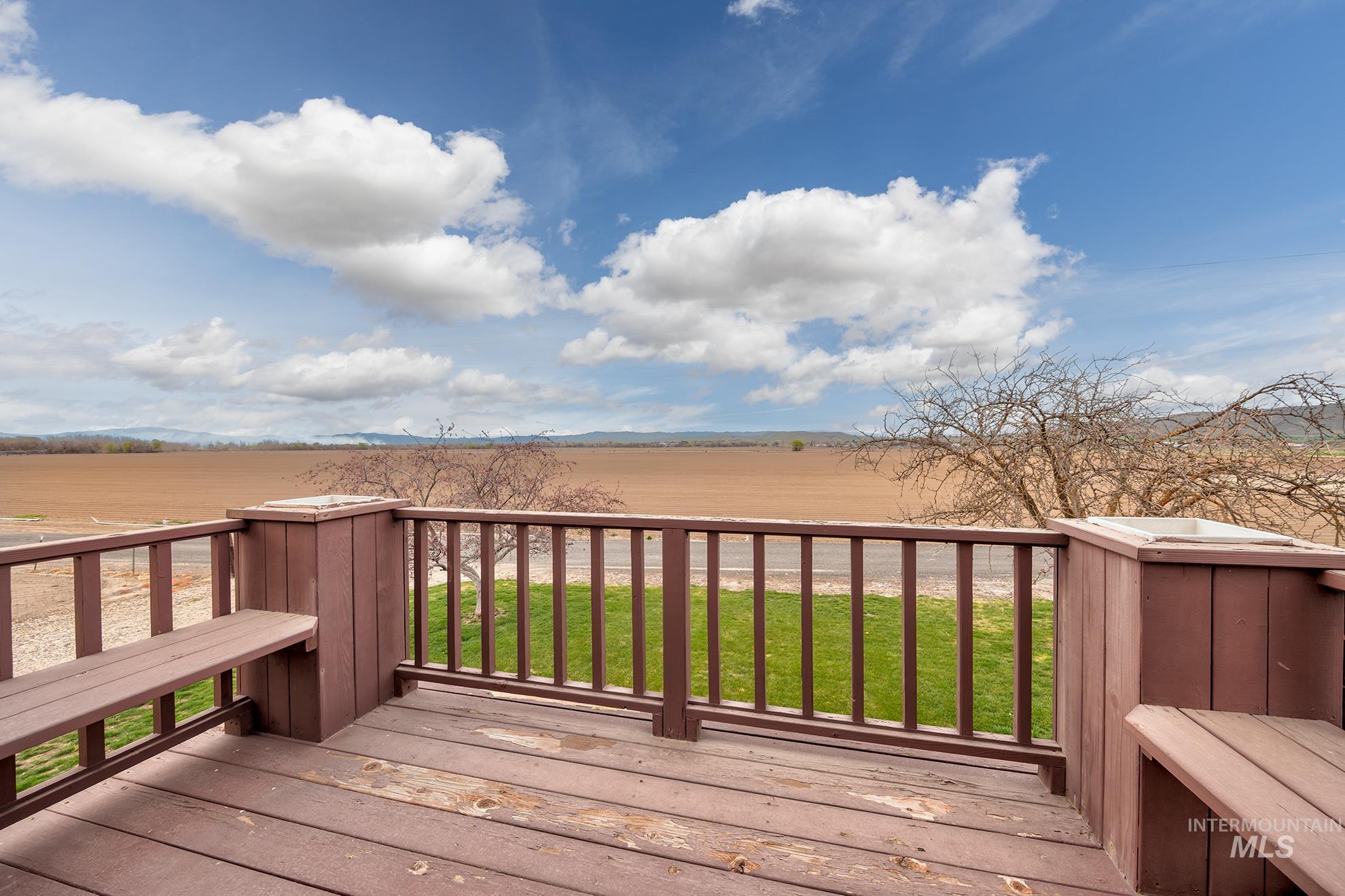 Wooden deck featuring a yard and a view of rural / pastoral area