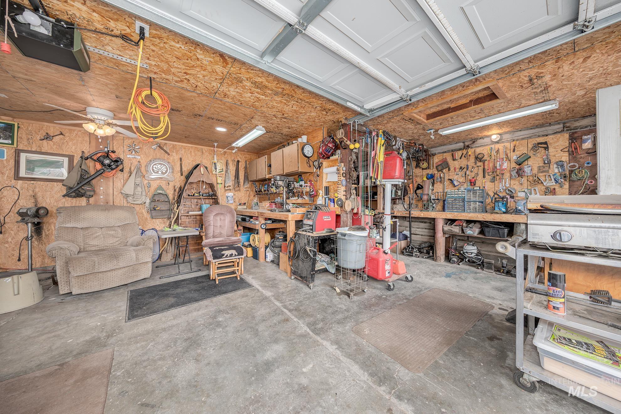 Garage featuring a workshop area, a ceiling fan, and a garage door opener