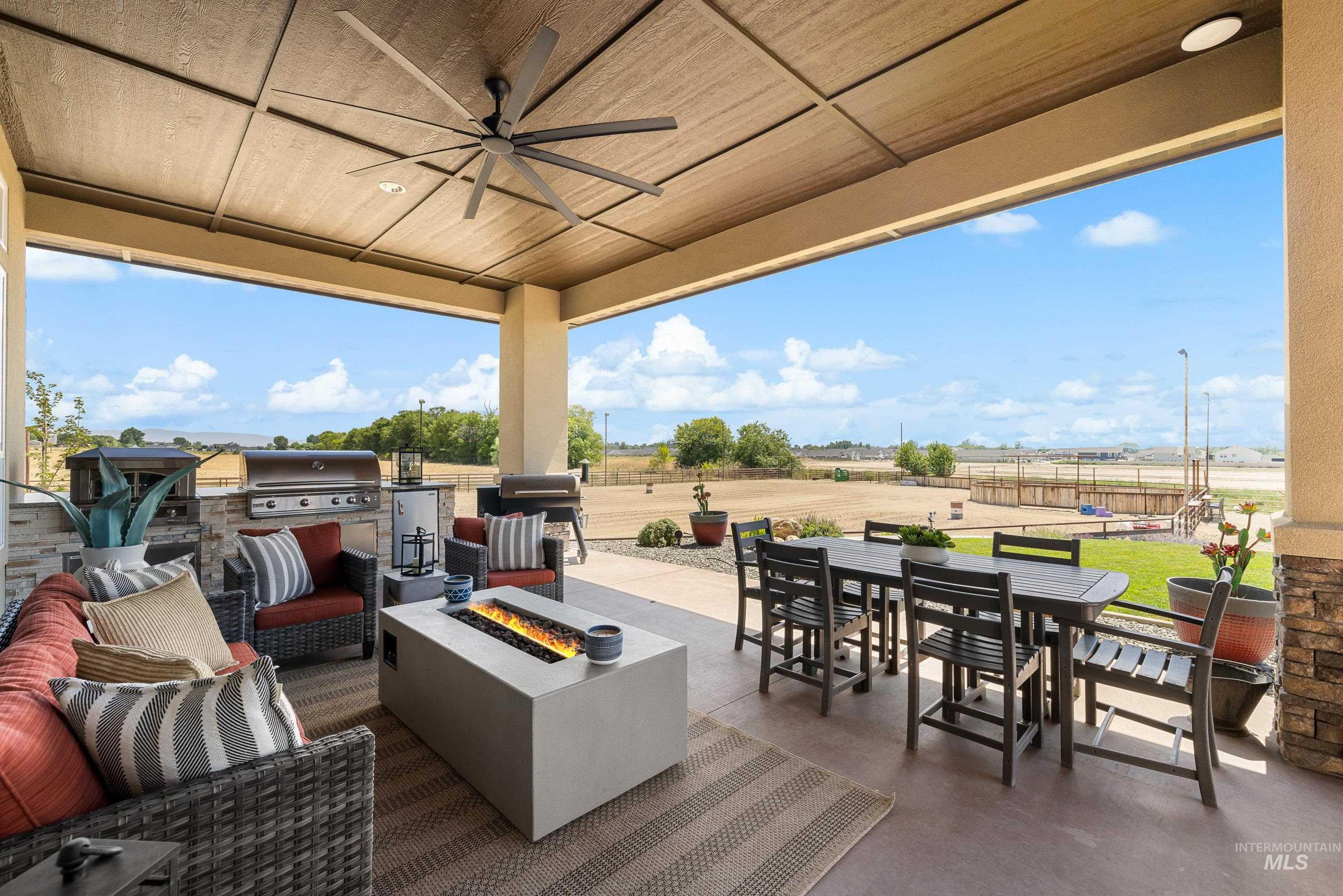 View of patio / terrace featuring outdoor dining space, a ceiling fan, an outdoor kitchen, and an outdoor living space with a fire pit
