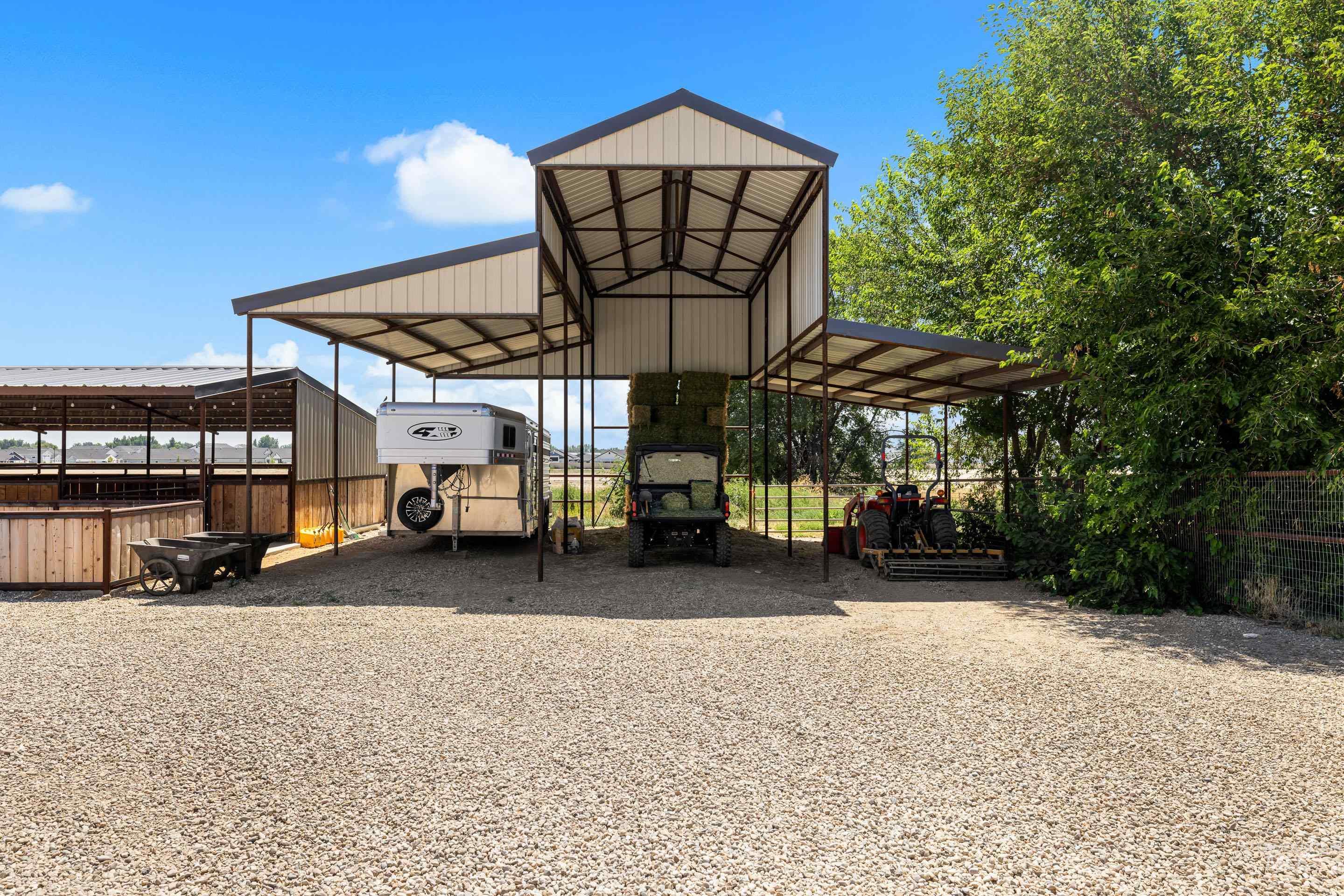 View of parking / parking lot featuring a carport and gravel driveway