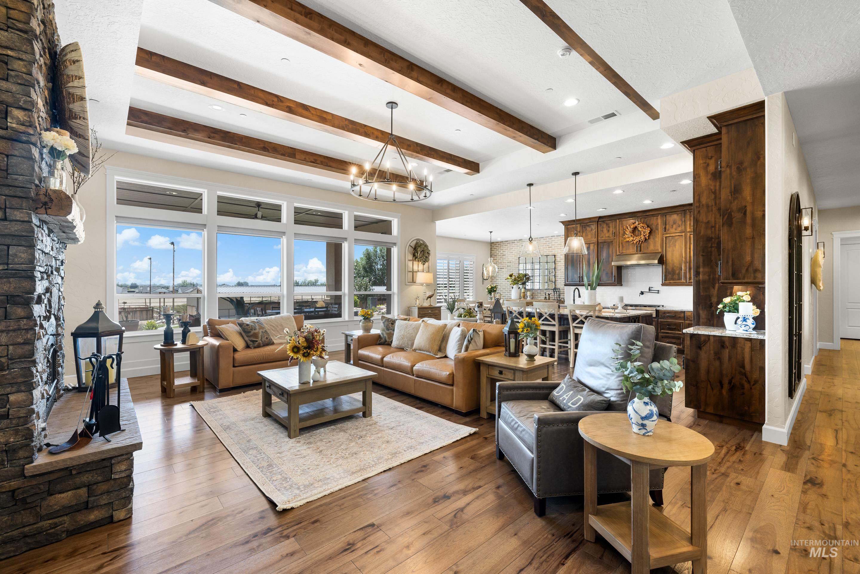 Living area with beam ceiling, a chandelier, hardwood / wood-style floors, recessed lighting, and a fireplace