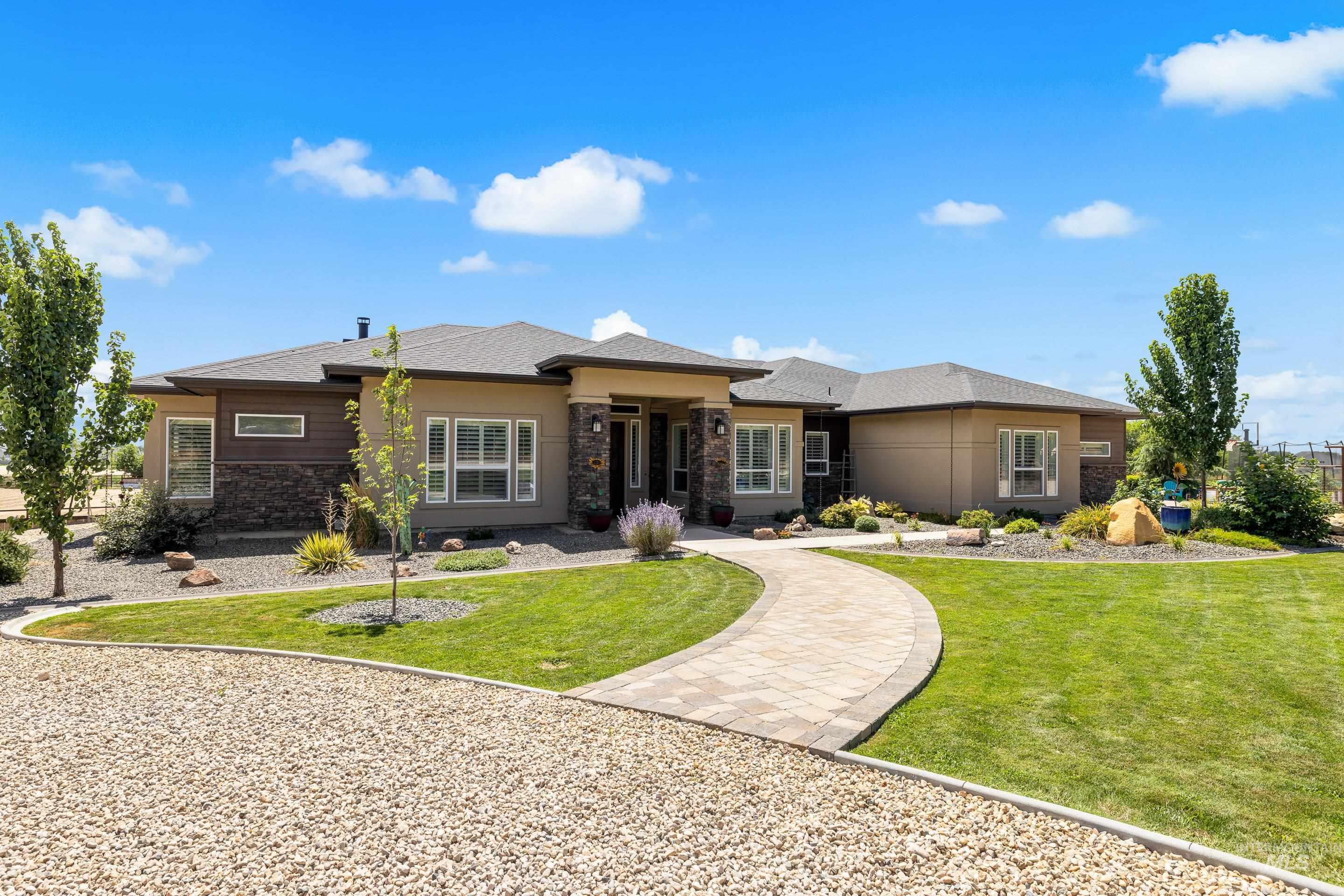 Prairie-style house with stone siding, a front lawn, and stucco siding