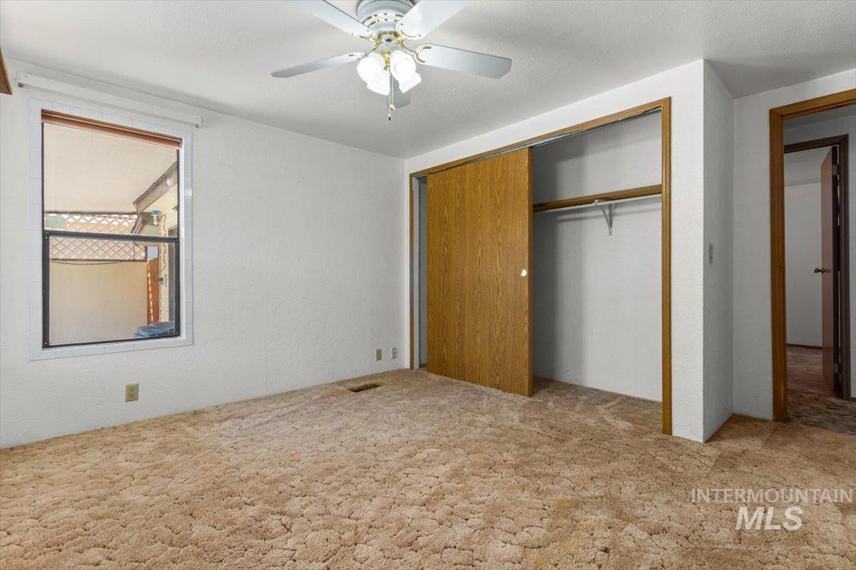Unfurnished bedroom featuring carpet floors, a ceiling fan, and a closet