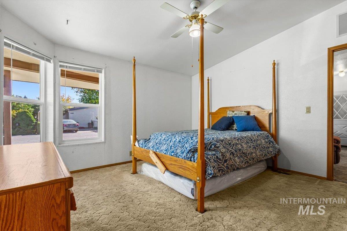 Bedroom featuring light carpet and ceiling fan