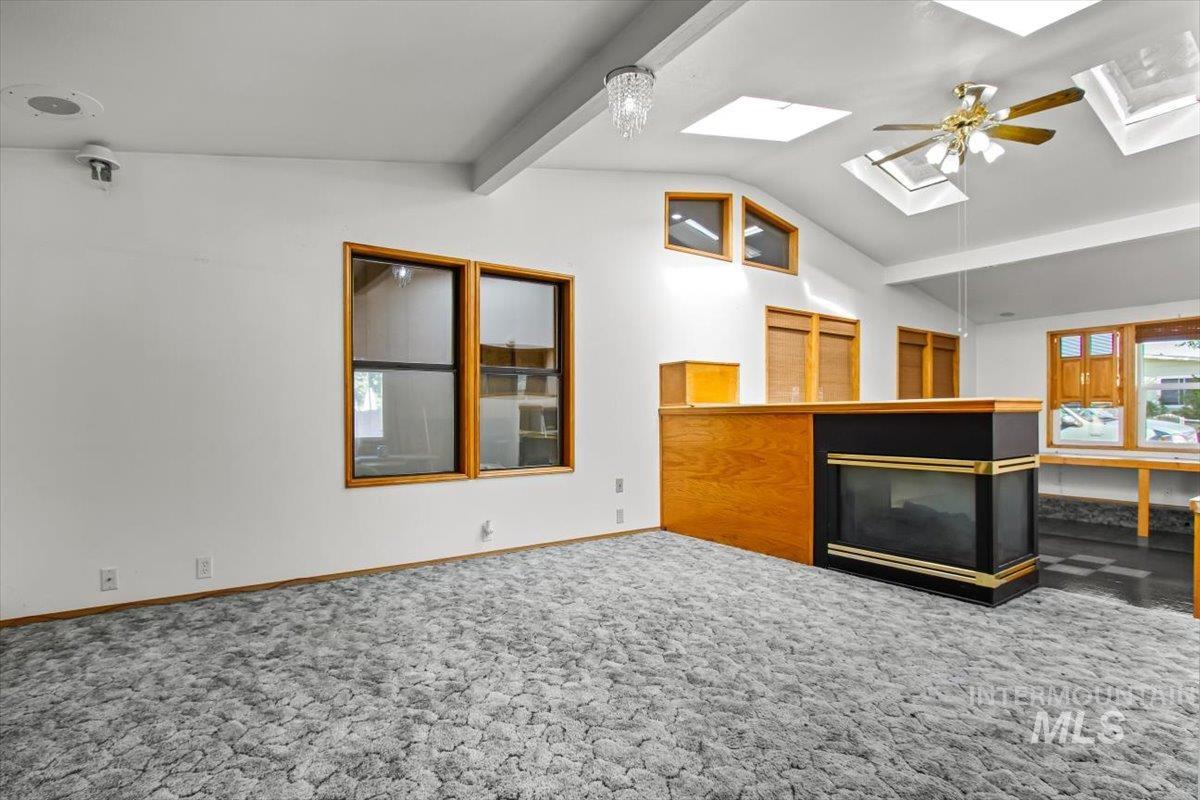 Bonus room with carpet floors, a skylight, and a ceiling fan