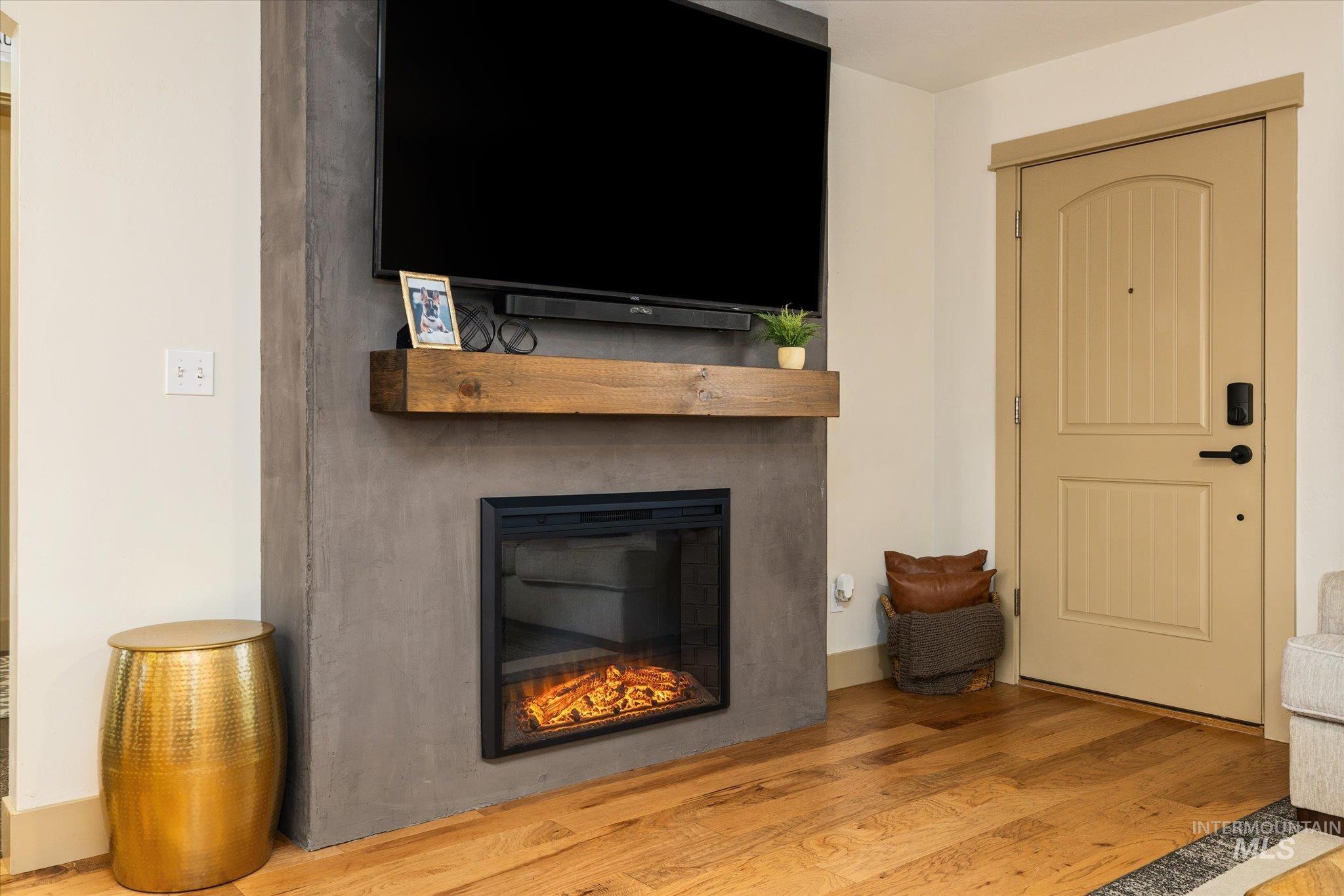 Living room featuring light wood-style flooring and a glass covered fireplace
