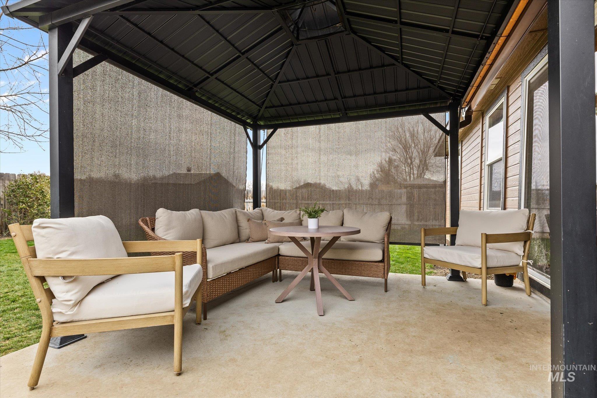 View of patio featuring a gazebo and an outdoor hangout area