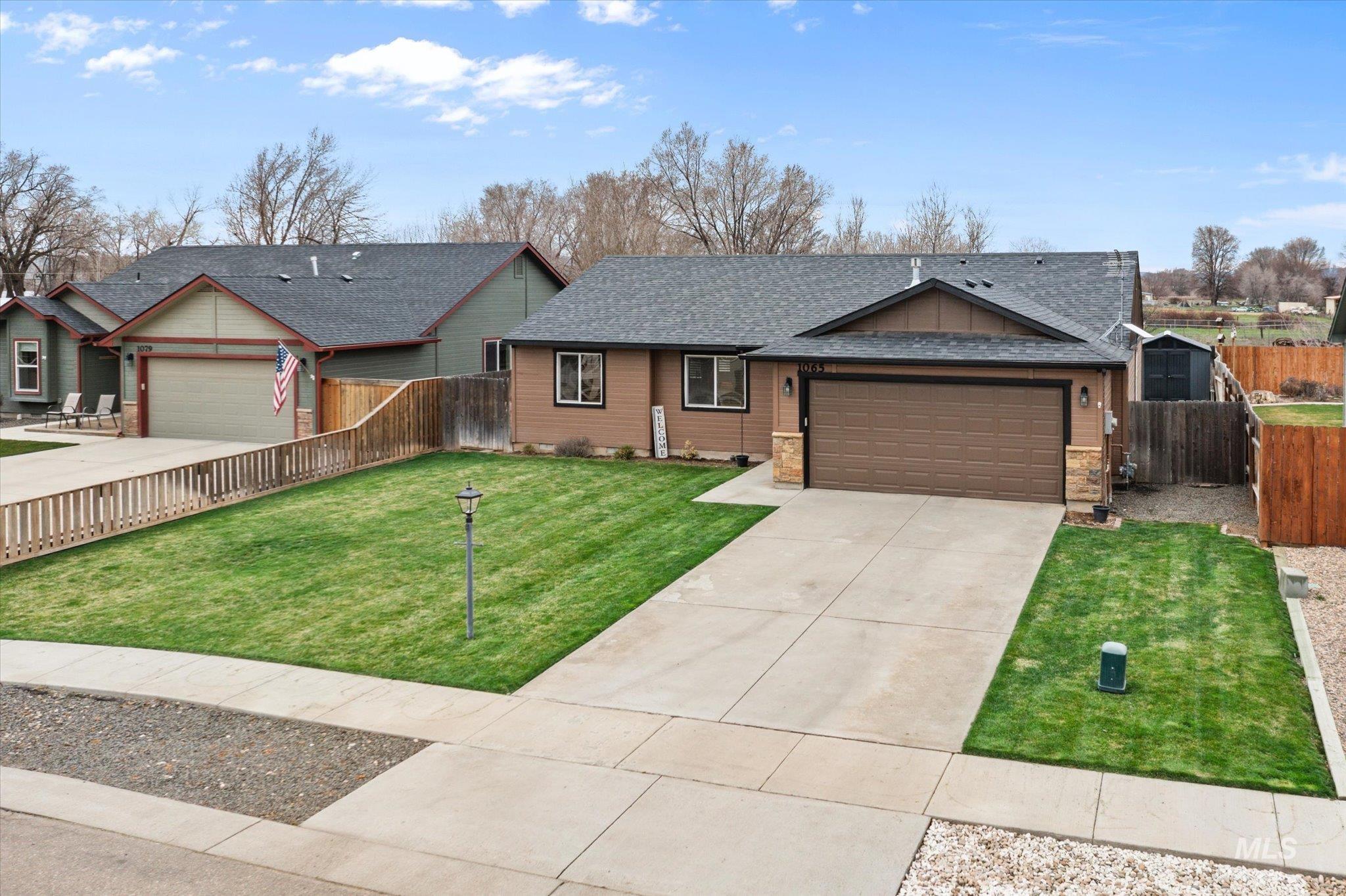Ranch-style house featuring an attached garage, driveway, and roof with shingles