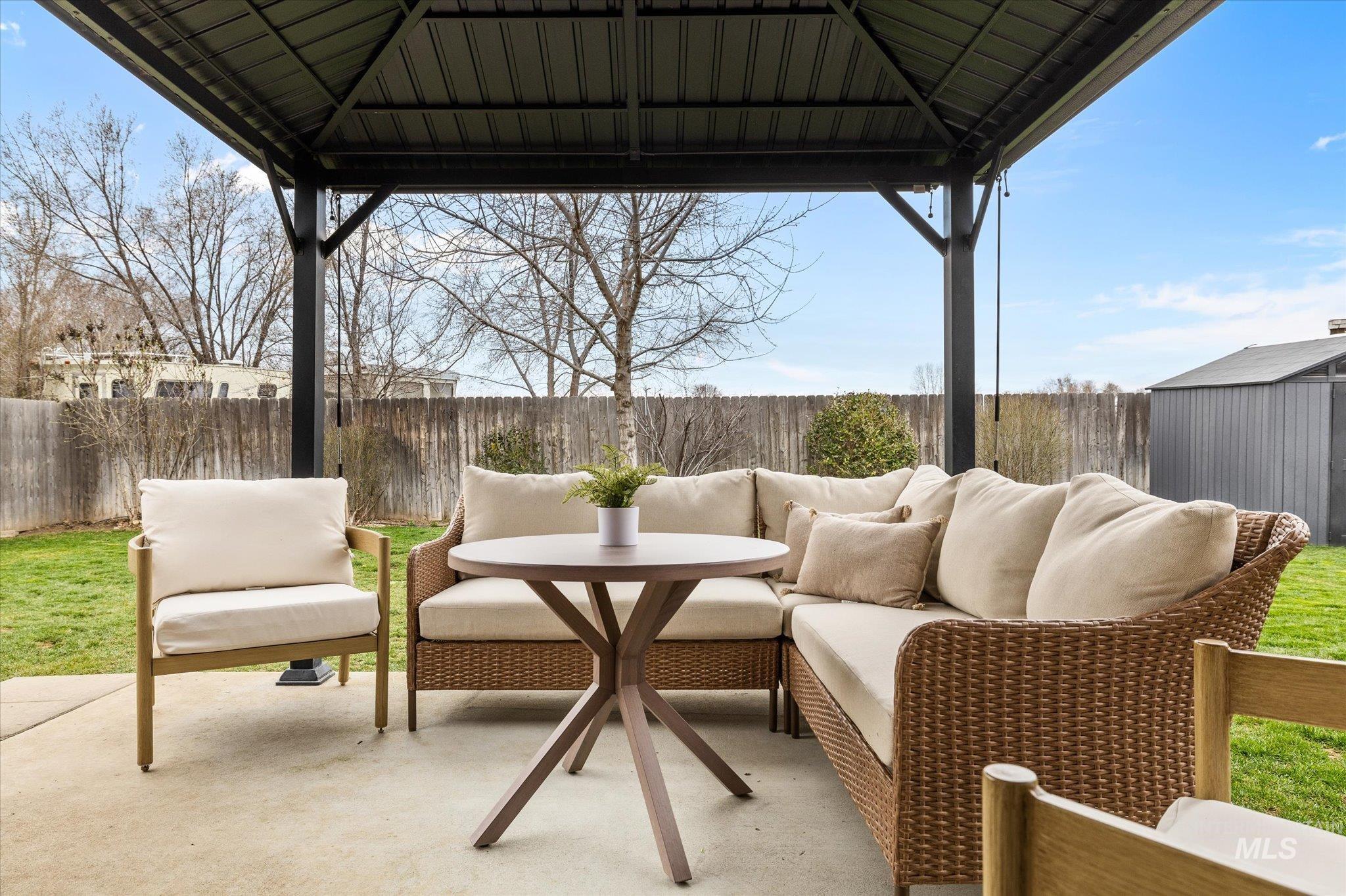 Fenced backyard with a gazebo, an outdoor lounge area, a patio, and a storage shed