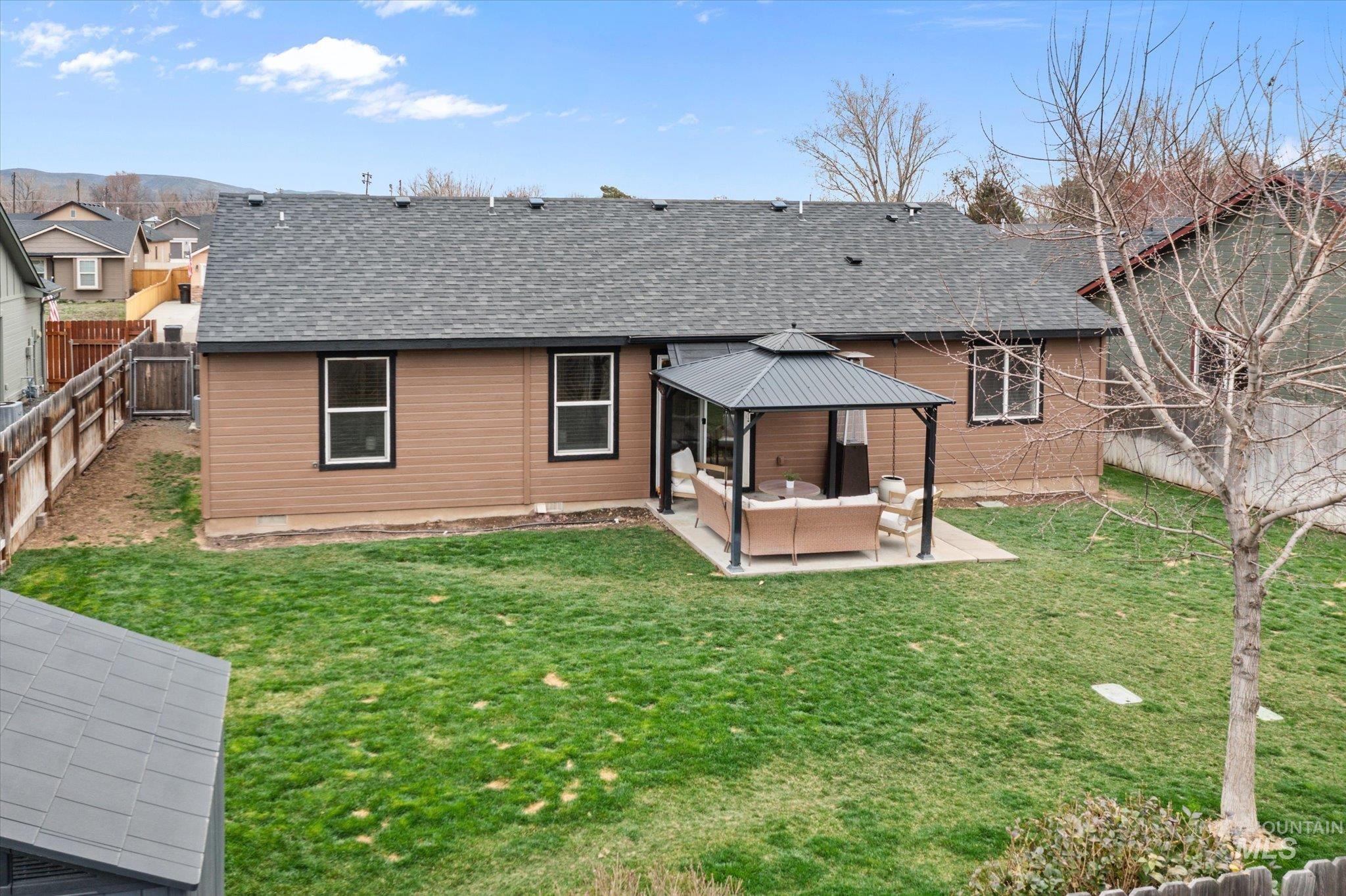 Rear view of house with outdoor furniture, roof with shingles, a gazebo, and a patio area