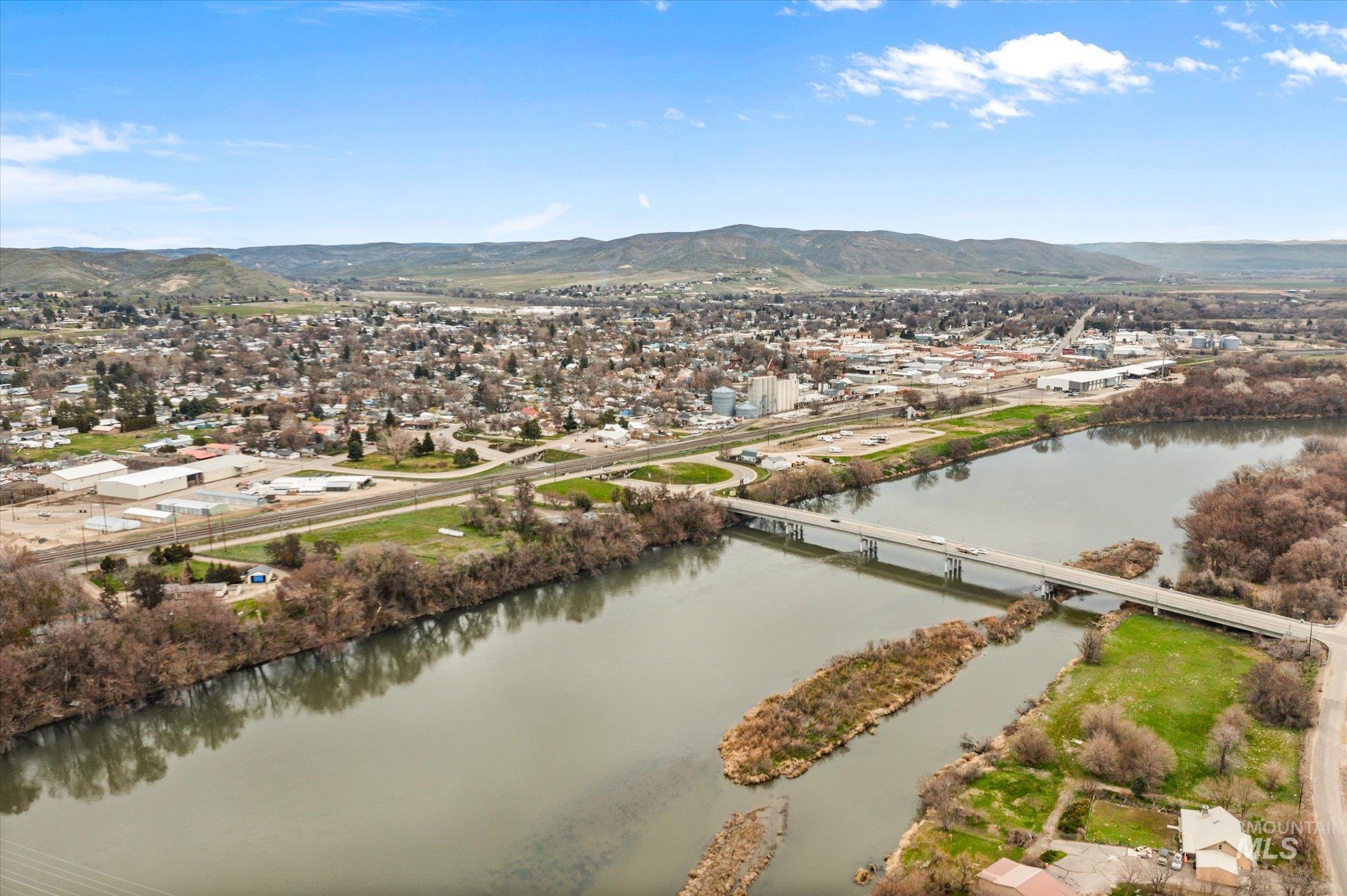 Aerial view of residential area featuring a notable bridge and a water and mountain view