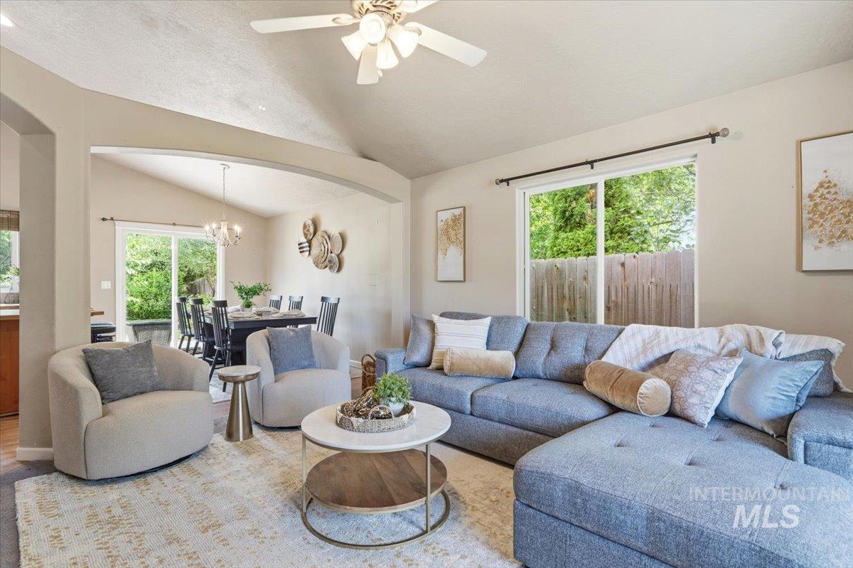 Living area featuring vaulted ceilings, a ceiling fan, and sliding glass doors