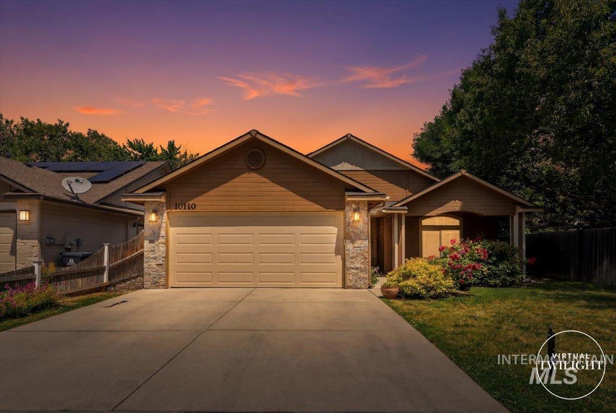 Single-story residence featuring a two-car garage, stone accents, and wood-finish siding