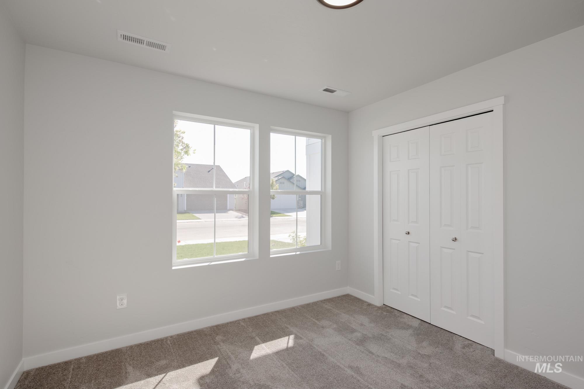 Unfurnished bedroom featuring light carpet and a closet