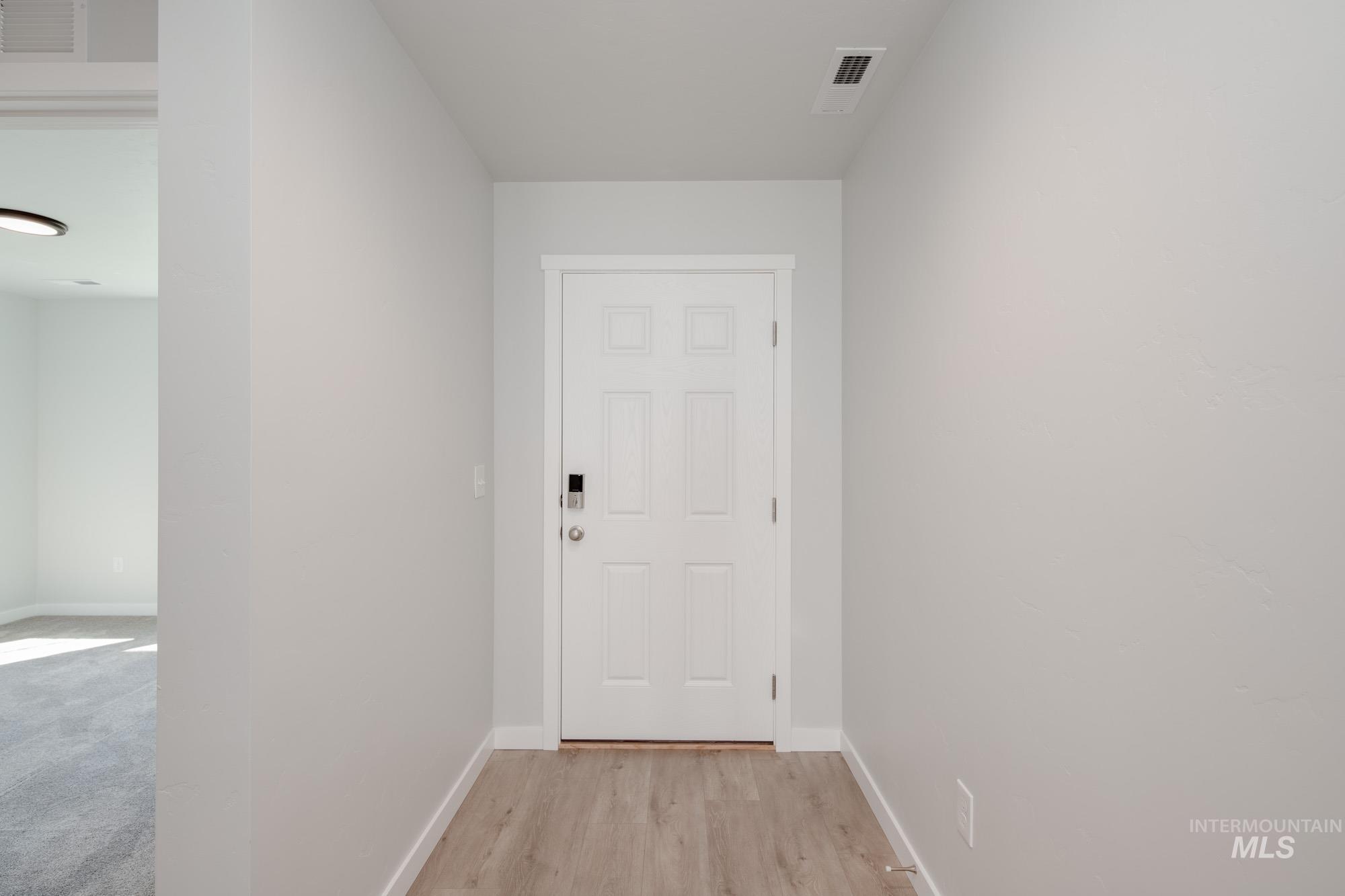 Doorway to outside with baseboards and wood finished floors