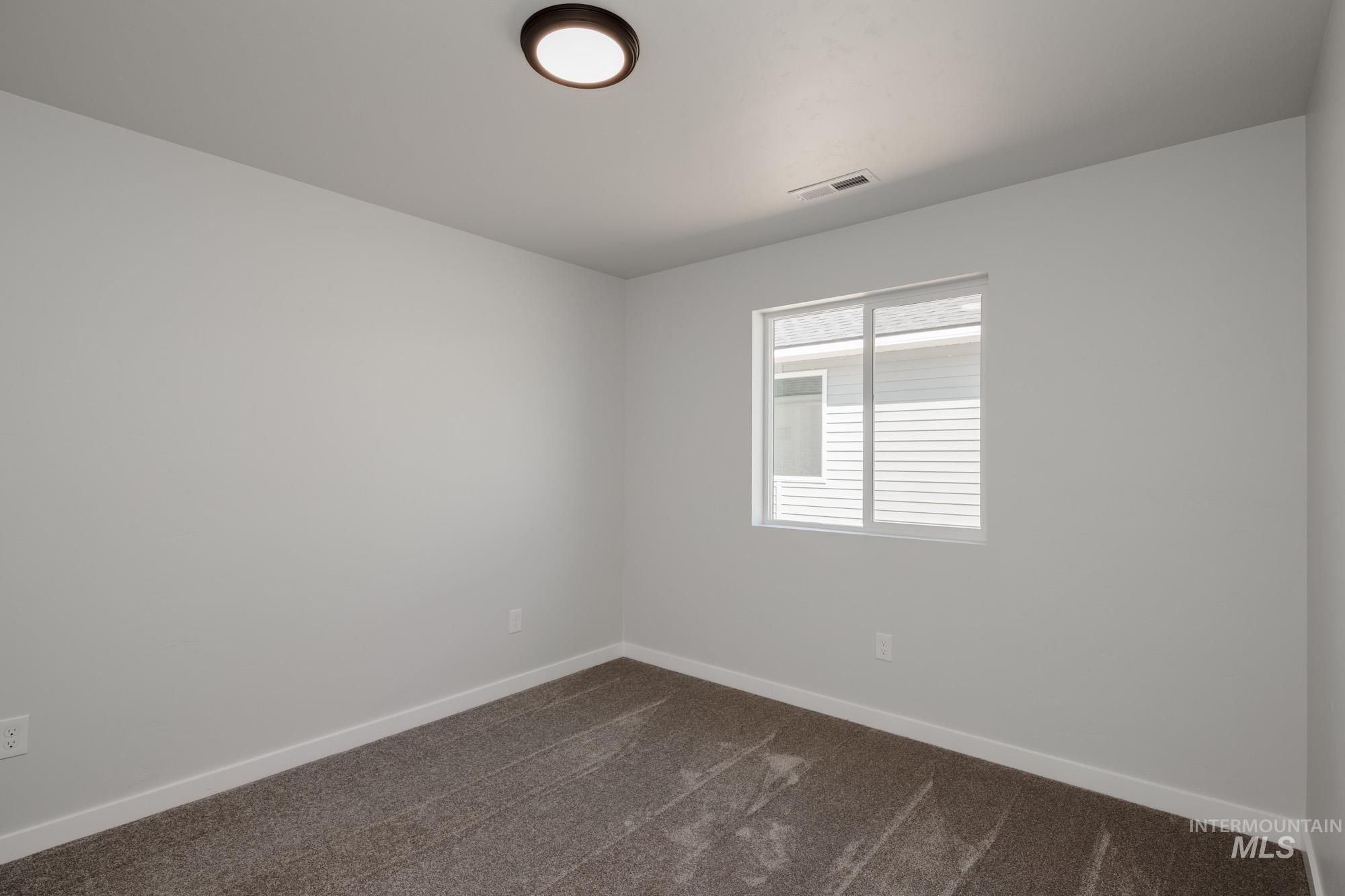 Empty room with dark carpet and baseboards
