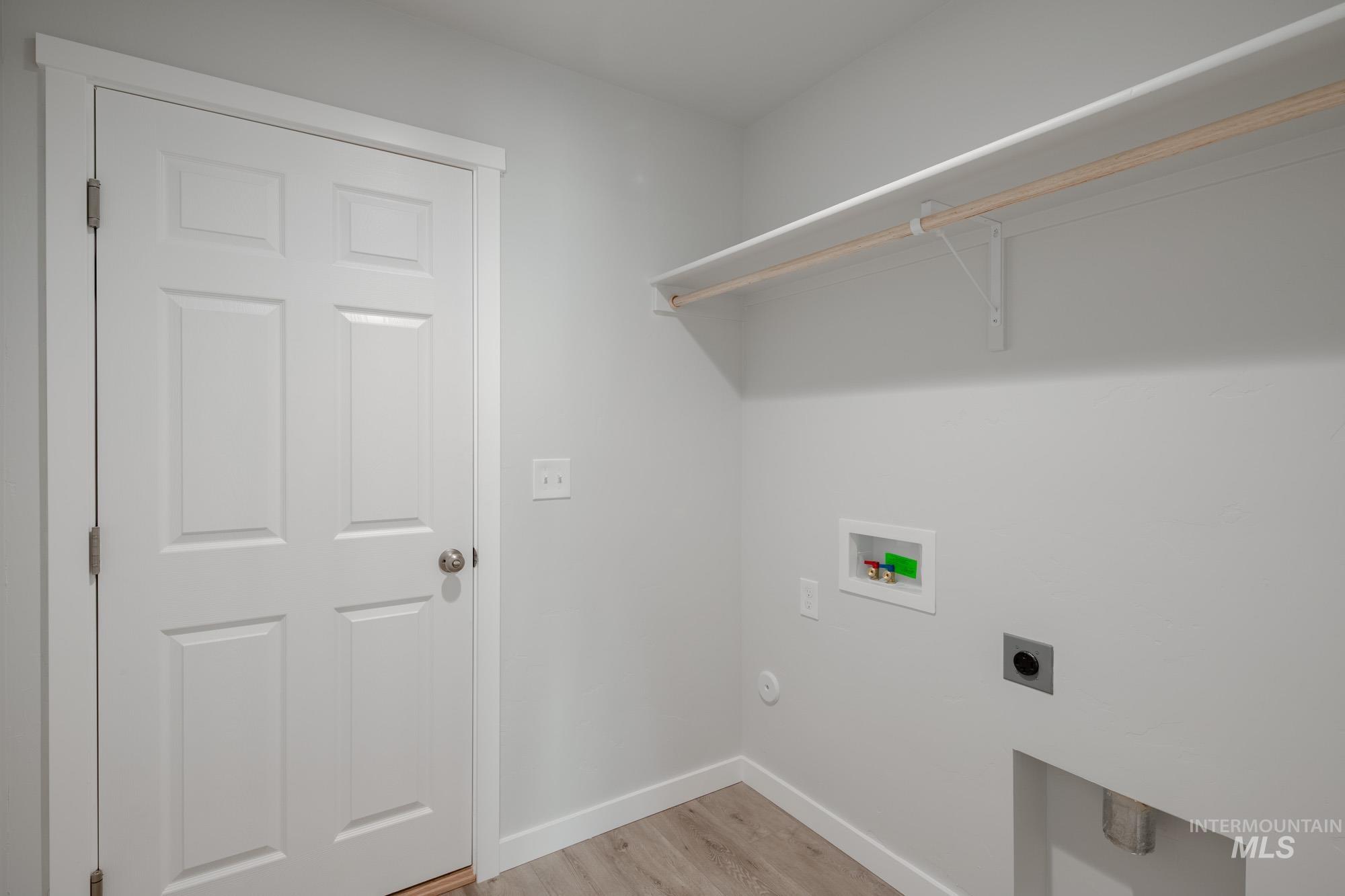 Laundry room featuring light wood finished floors, washer hookup, and hookup for an electric dryer