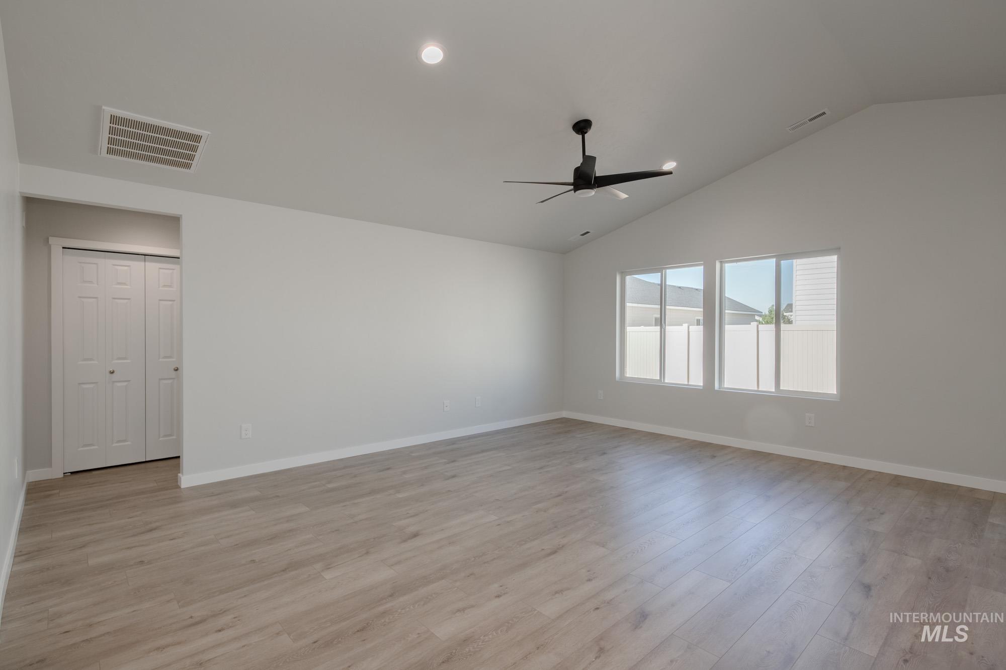 Unfurnished room with light wood-style floors, vaulted ceiling, recessed lighting, and a ceiling fan
