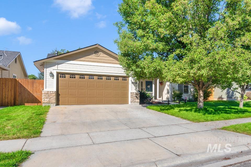 View of front of property with stone siding, concrete driveway, and an attached garage