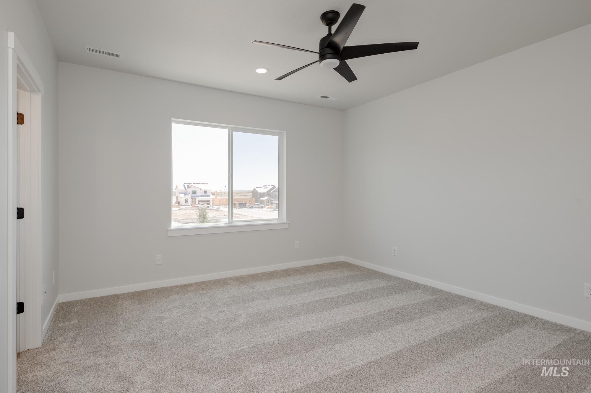 Empty room featuring light carpet, a ceiling fan, and recessed lighting