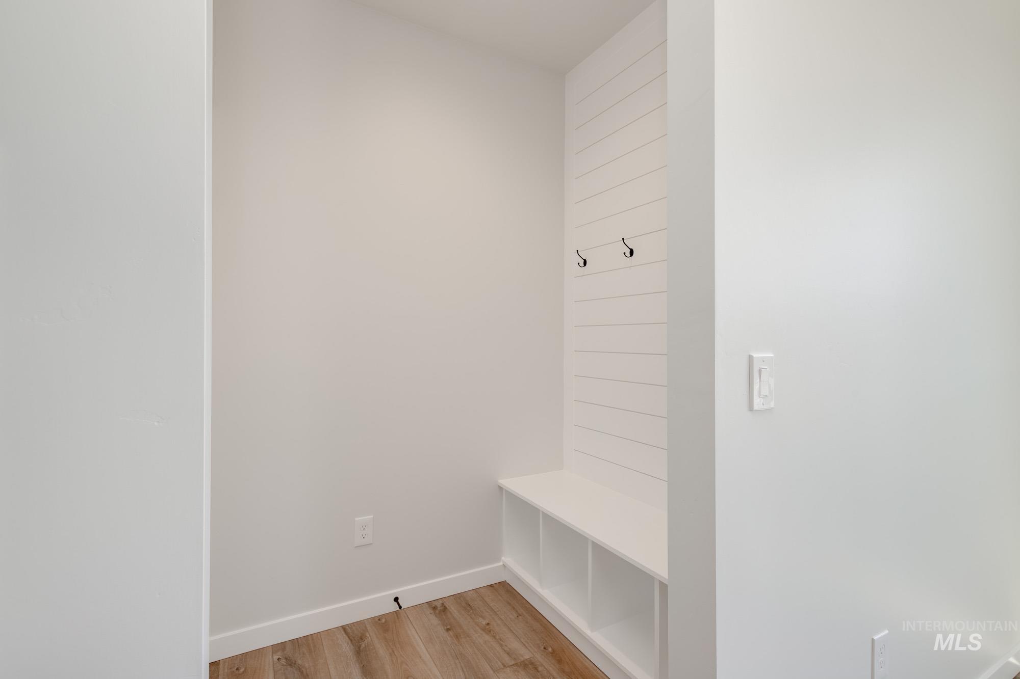 Mudroom featuring light wood finished floors and baseboards