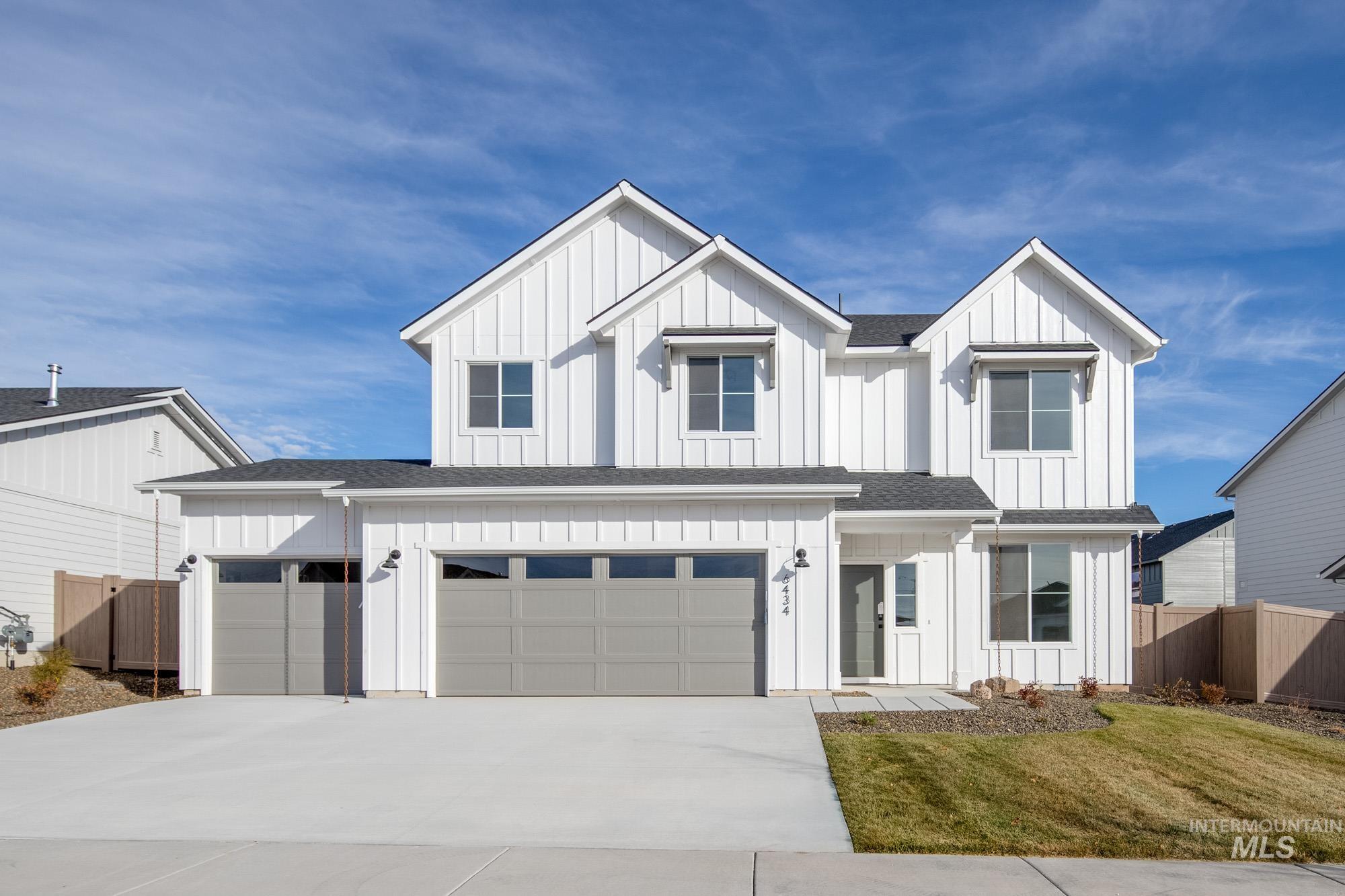 Modern farmhouse featuring board and batten siding, roof with shingles, driveway, and a garage