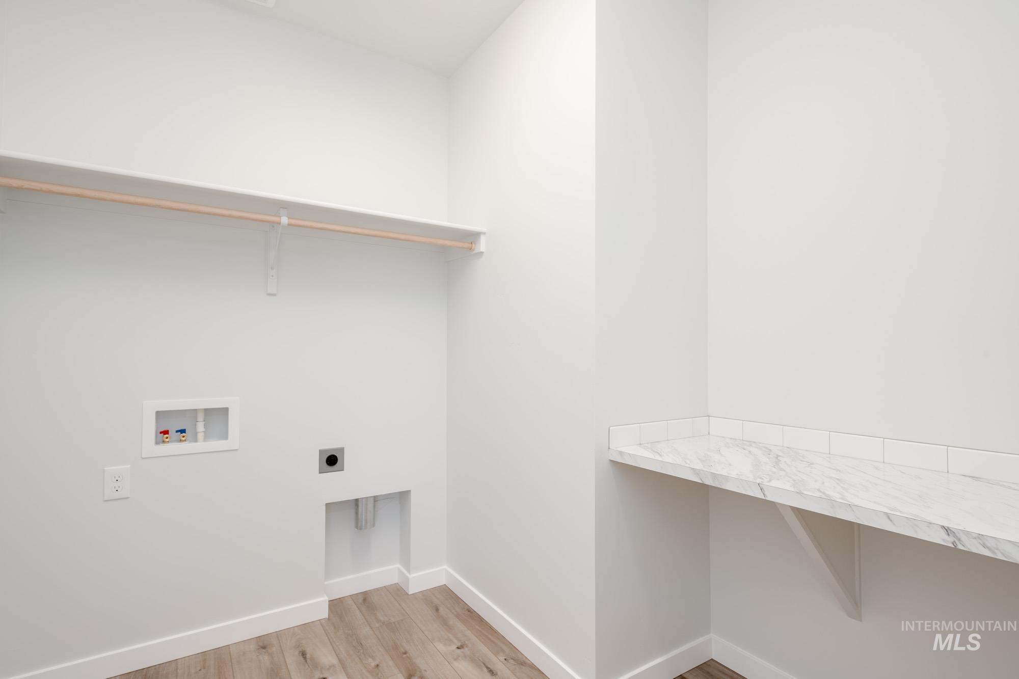 Washroom featuring electric dryer hookup, washer hookup, and light wood-style floors