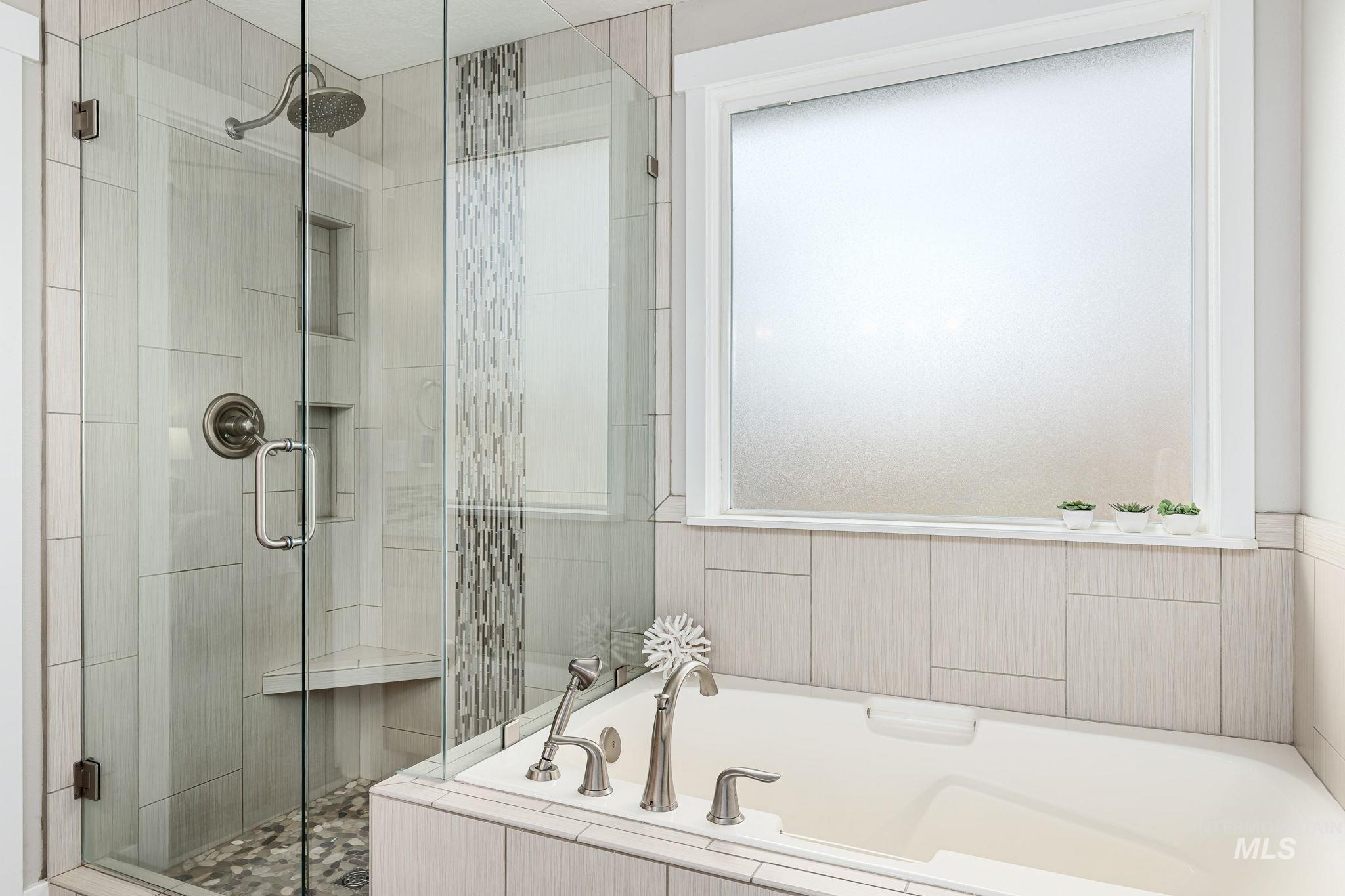 Full bath with a garden tub, a shower stall, and plenty of natural light