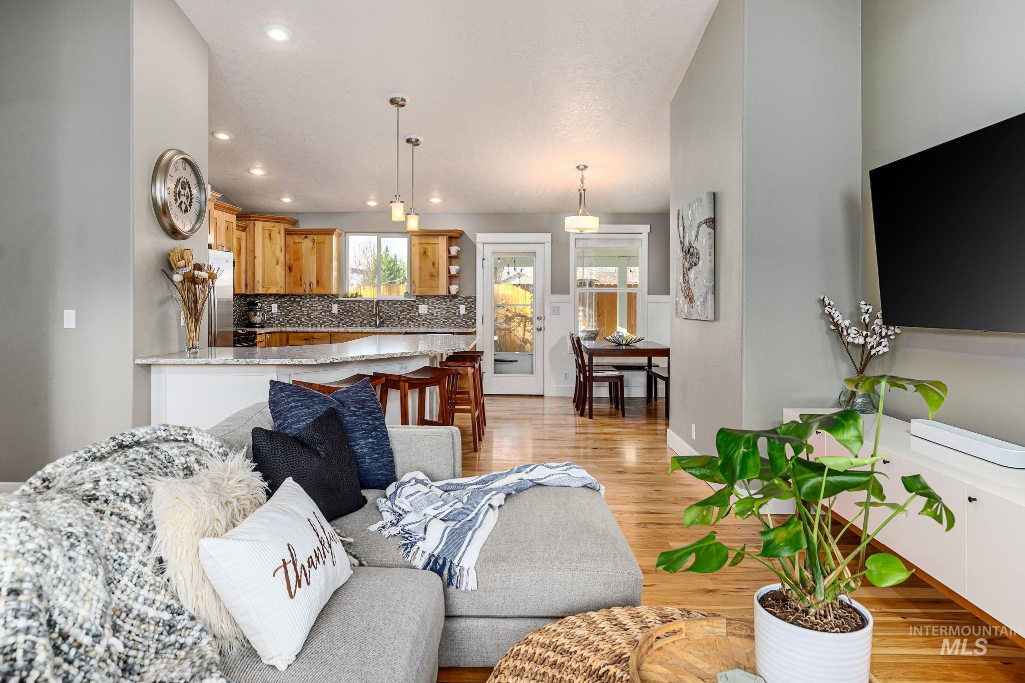 Living room with light wood-type flooring and recessed lighting