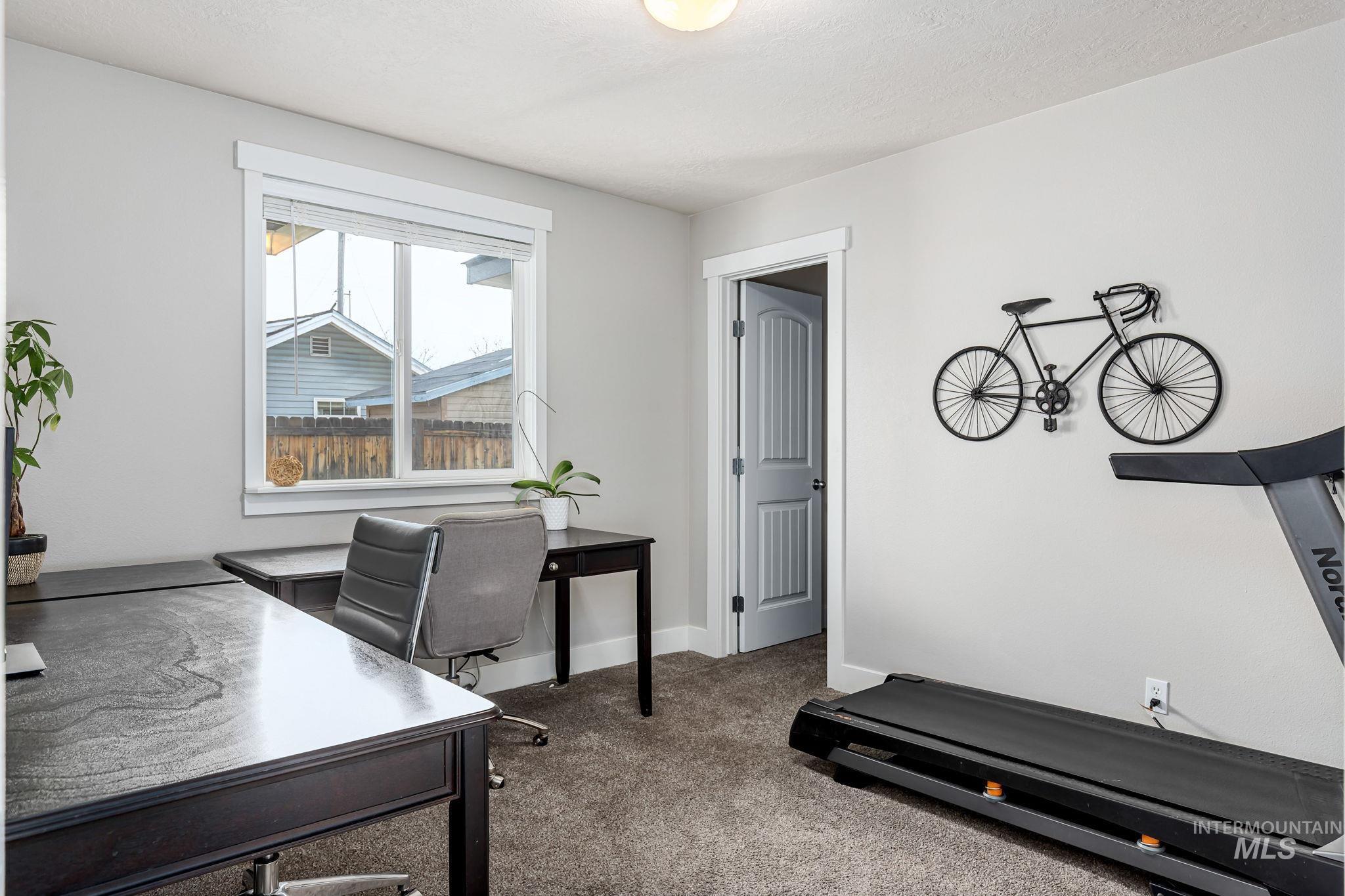Home office with light carpet and baseboards