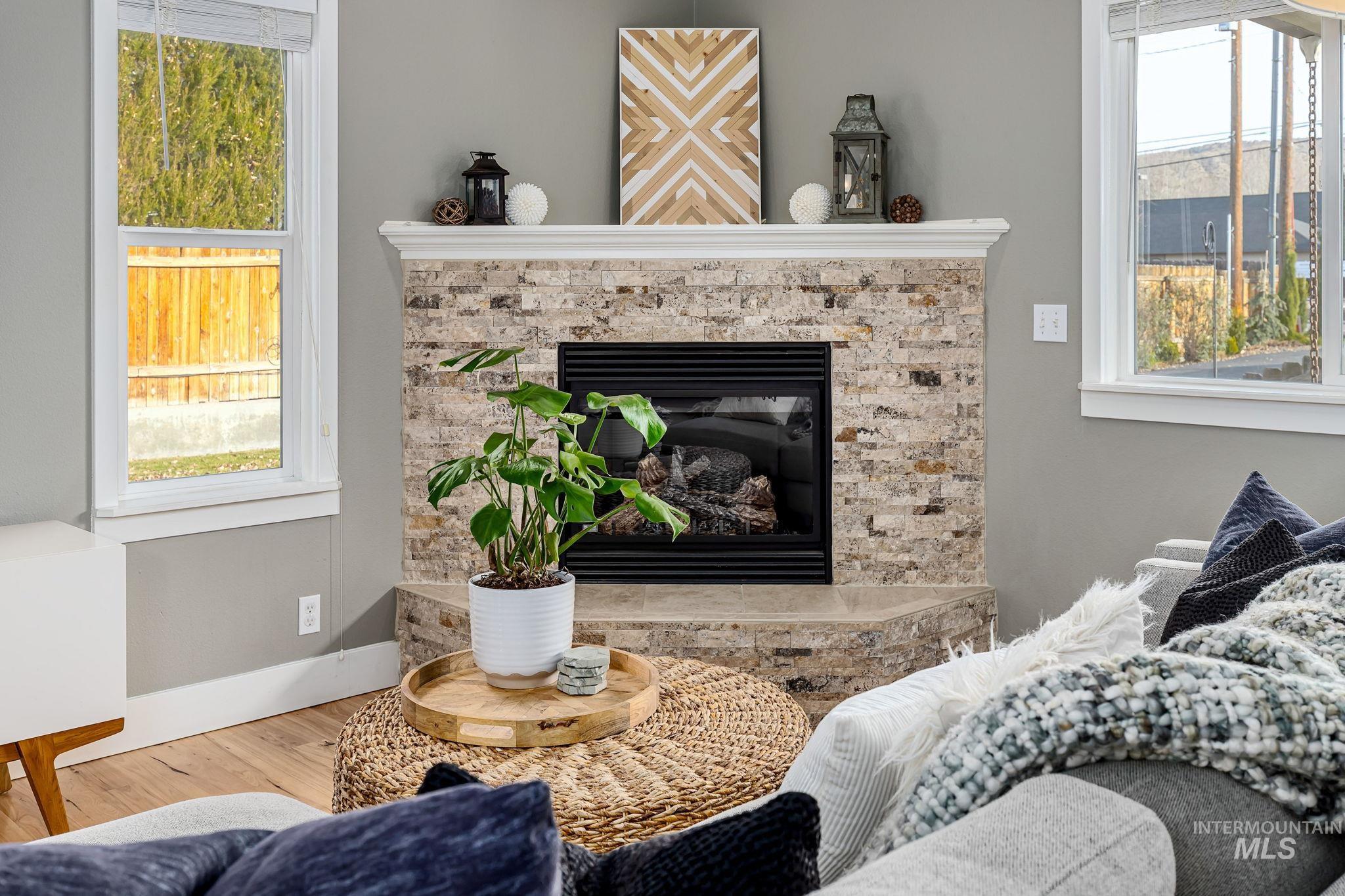 Living area featuring wood finished floors and a glass covered fireplace
