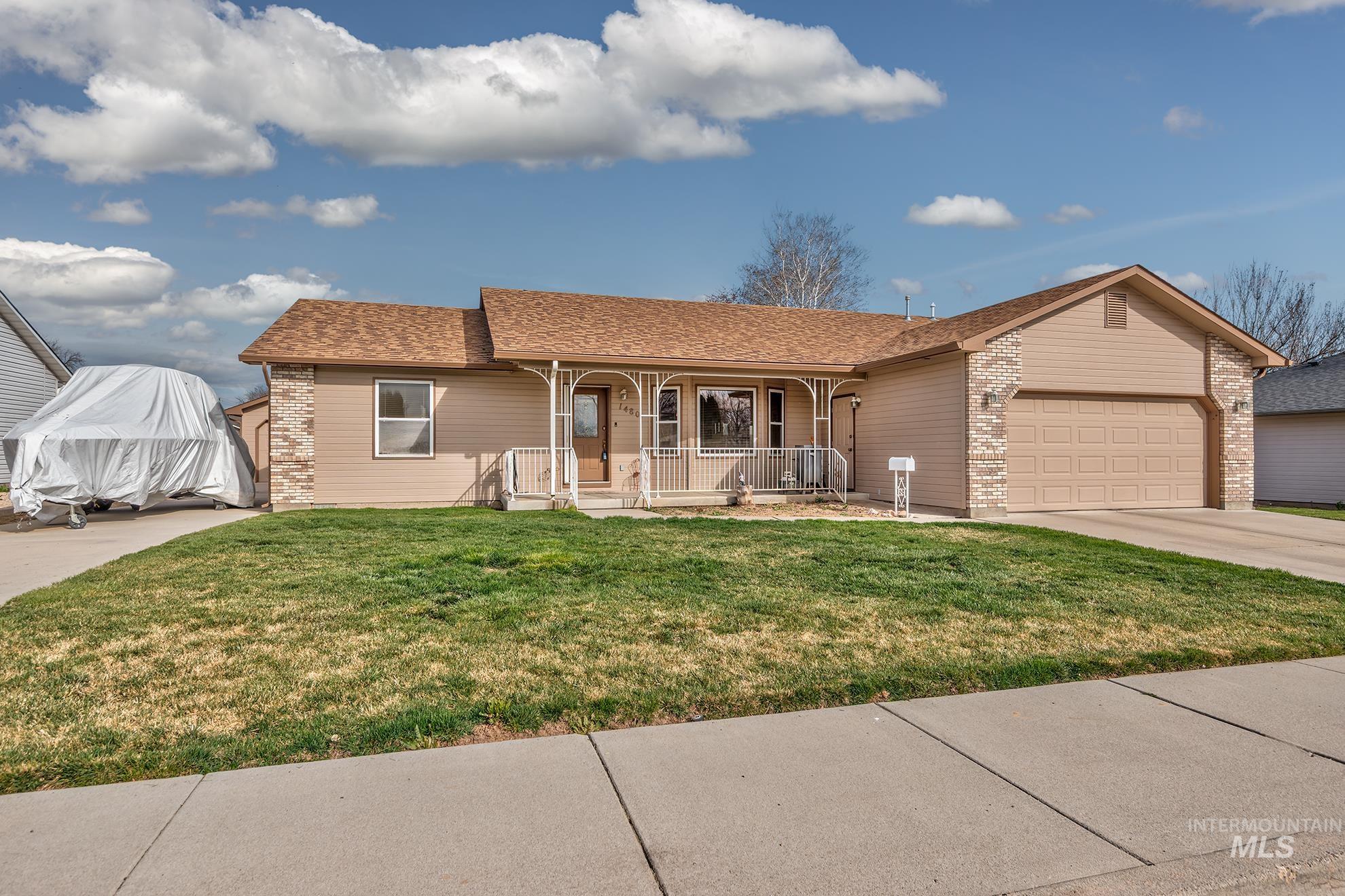 Single story home featuring covered porch, an attached garage, a front lawn, a shingled roof, and concrete driveway