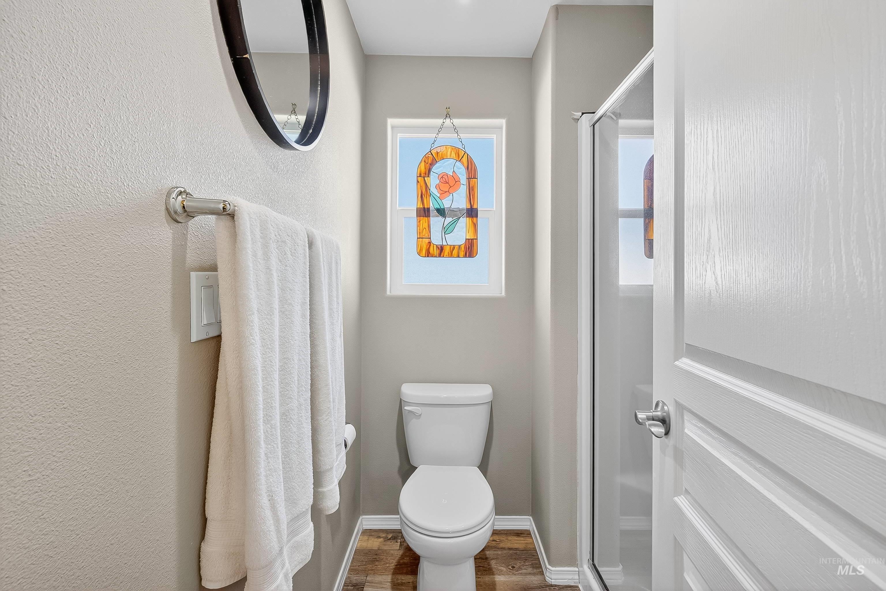 Bathroom with wood finished floors and a stall shower