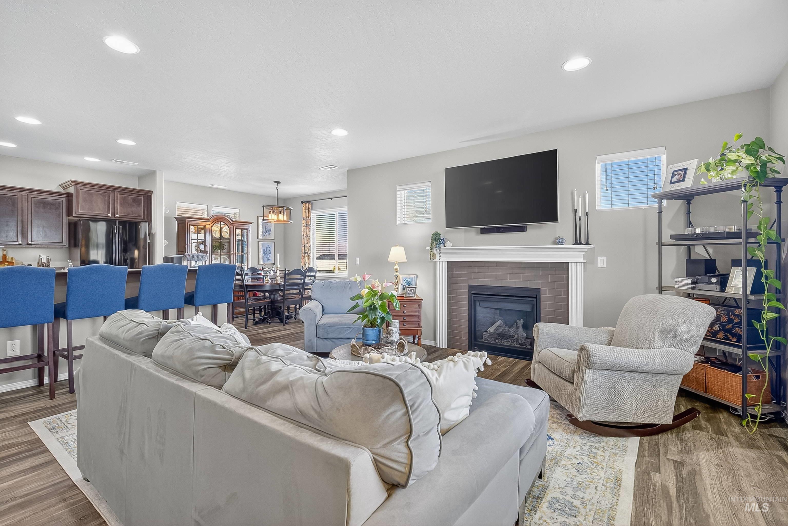 Living area featuring wood finished floors, recessed lighting, and a brick fireplace