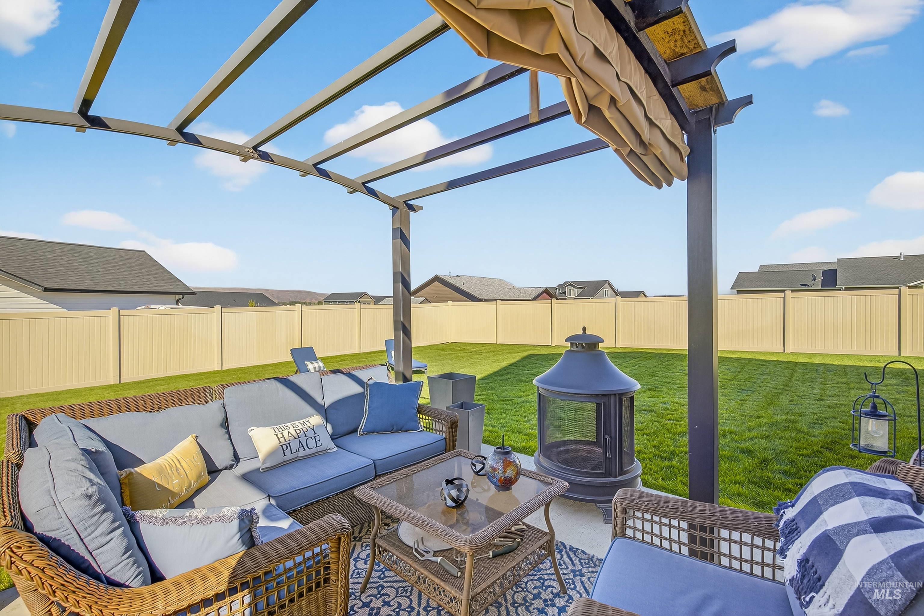 Fenced backyard featuring a pergola, an outdoor living space, and a patio