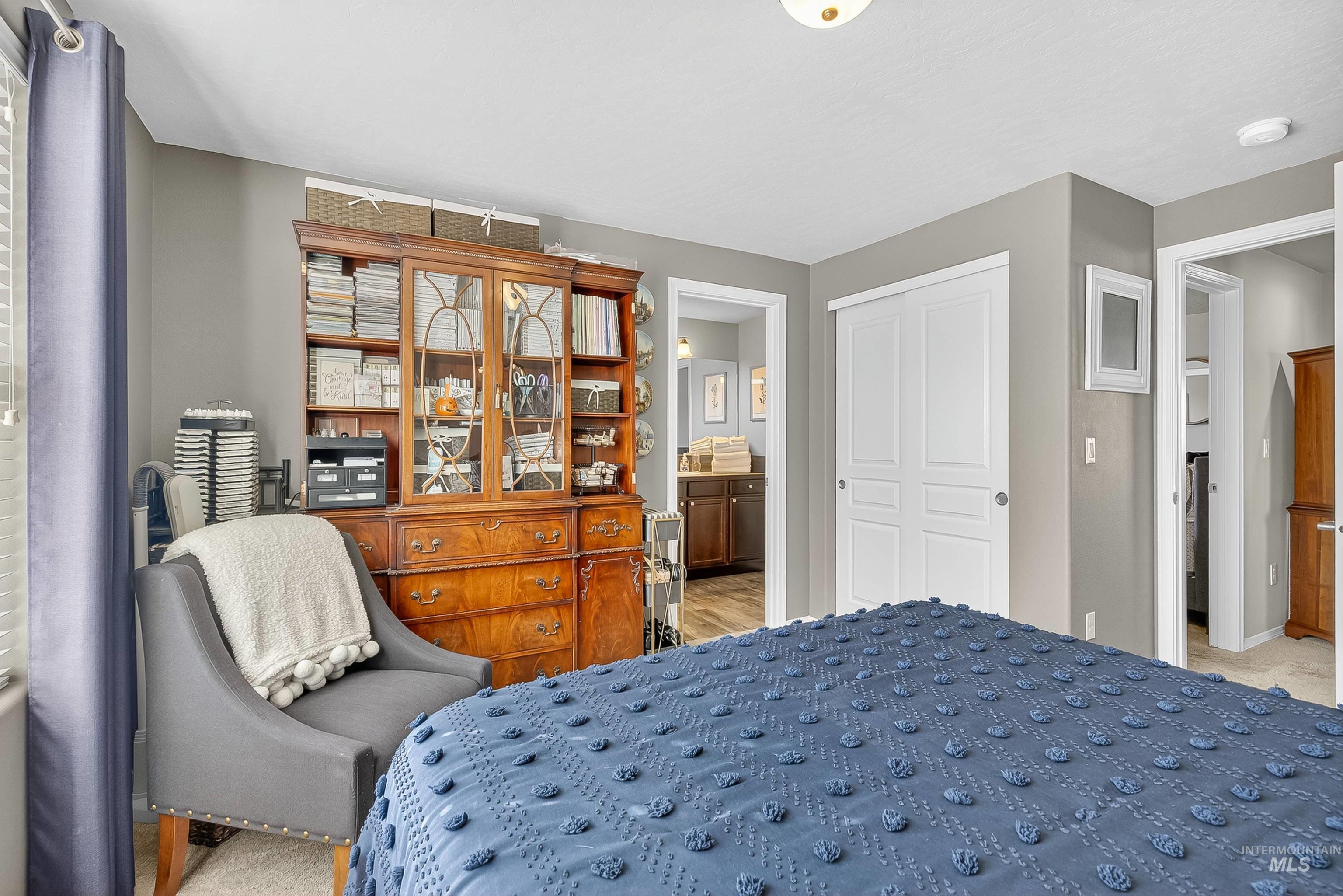 Bedroom featuring a closet, ensuite bathroom, and light carpet