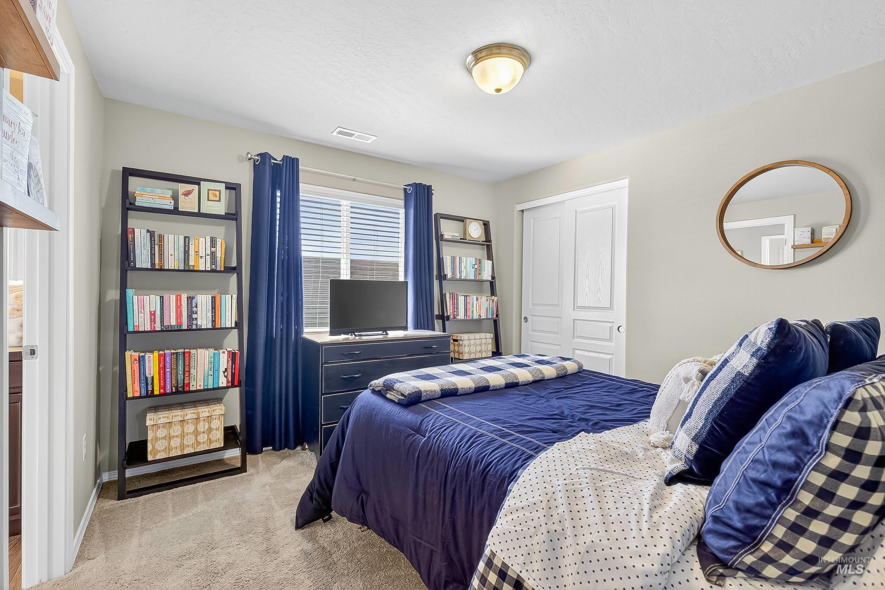Bedroom featuring light colored carpet and a closet