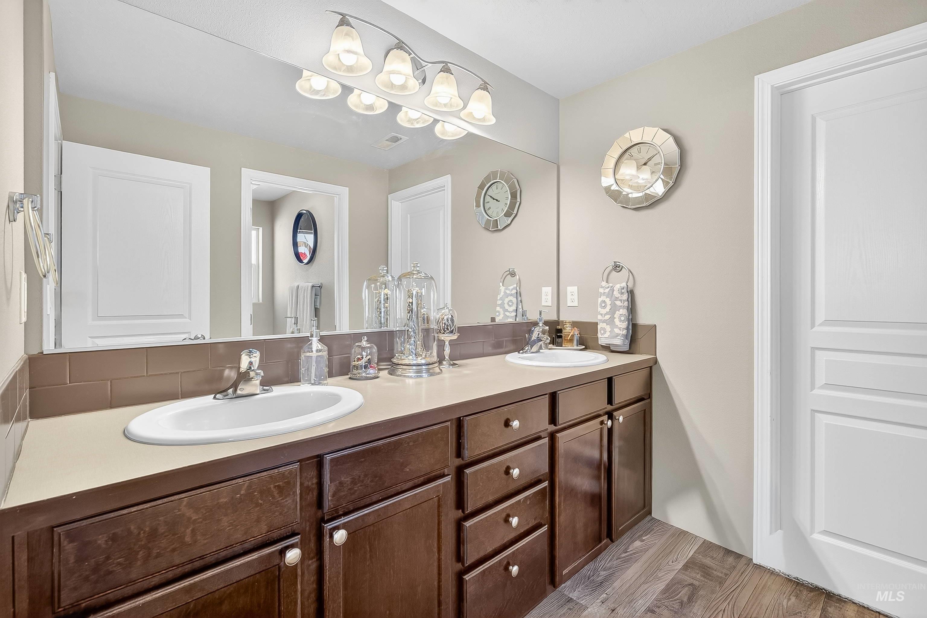 Bathroom featuring double vanity and light wood-type flooring