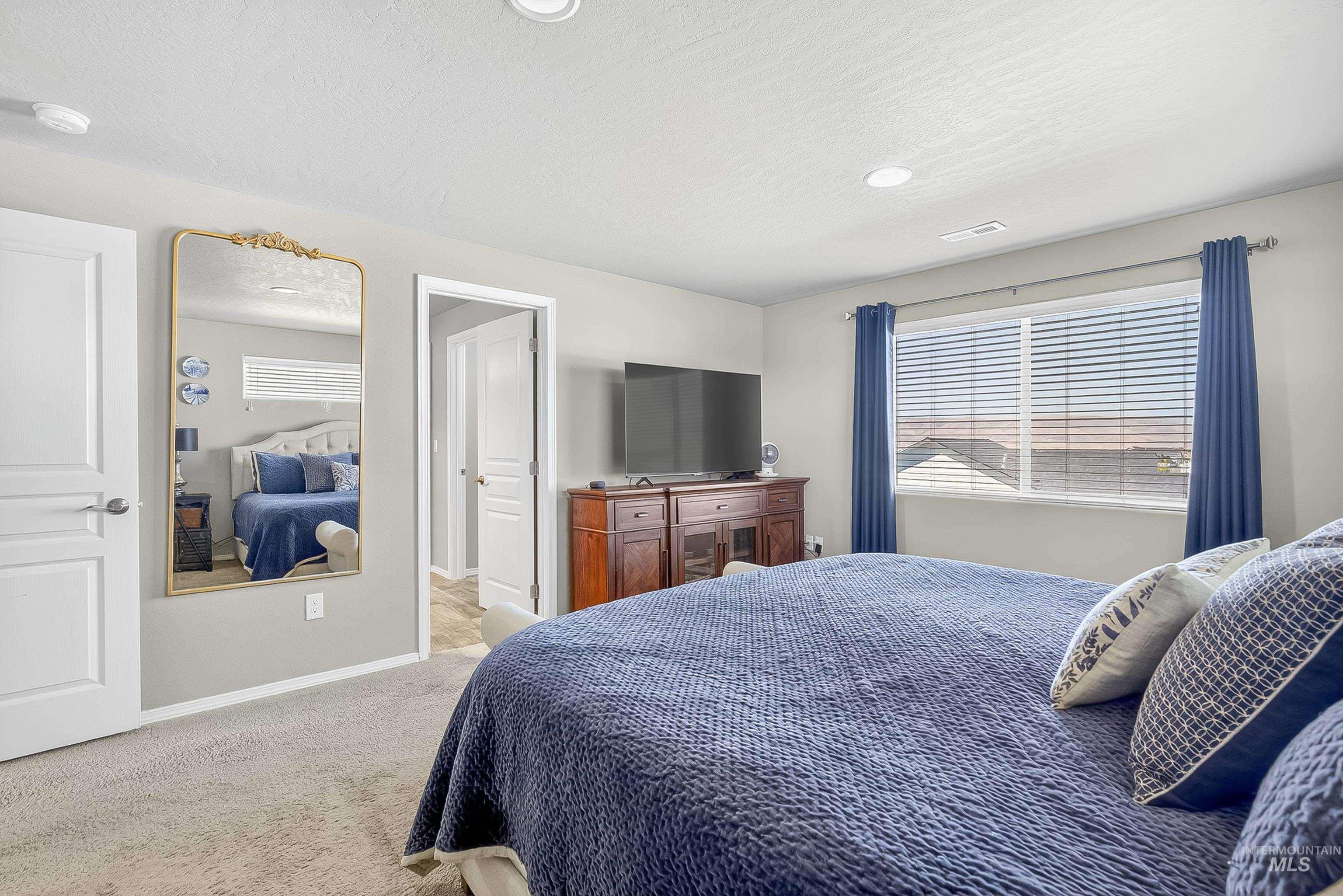 Bedroom featuring carpet, a textured ceiling, and recessed lighting