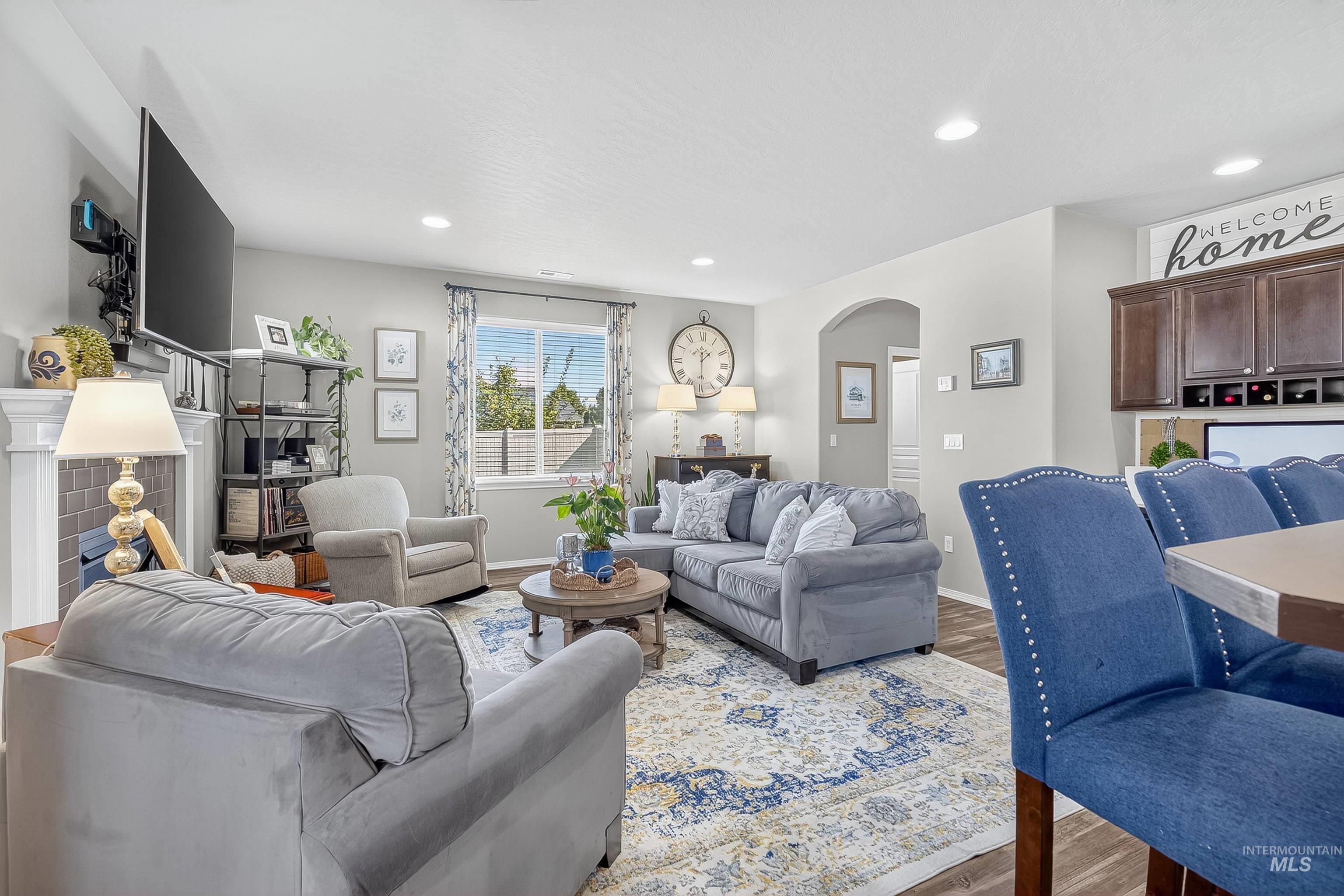 Living area featuring arched walkways, wood finished floors, recessed lighting, and a fireplace