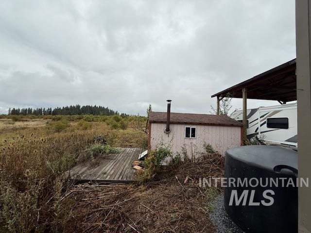 View of yard with a wooden deck and a shed