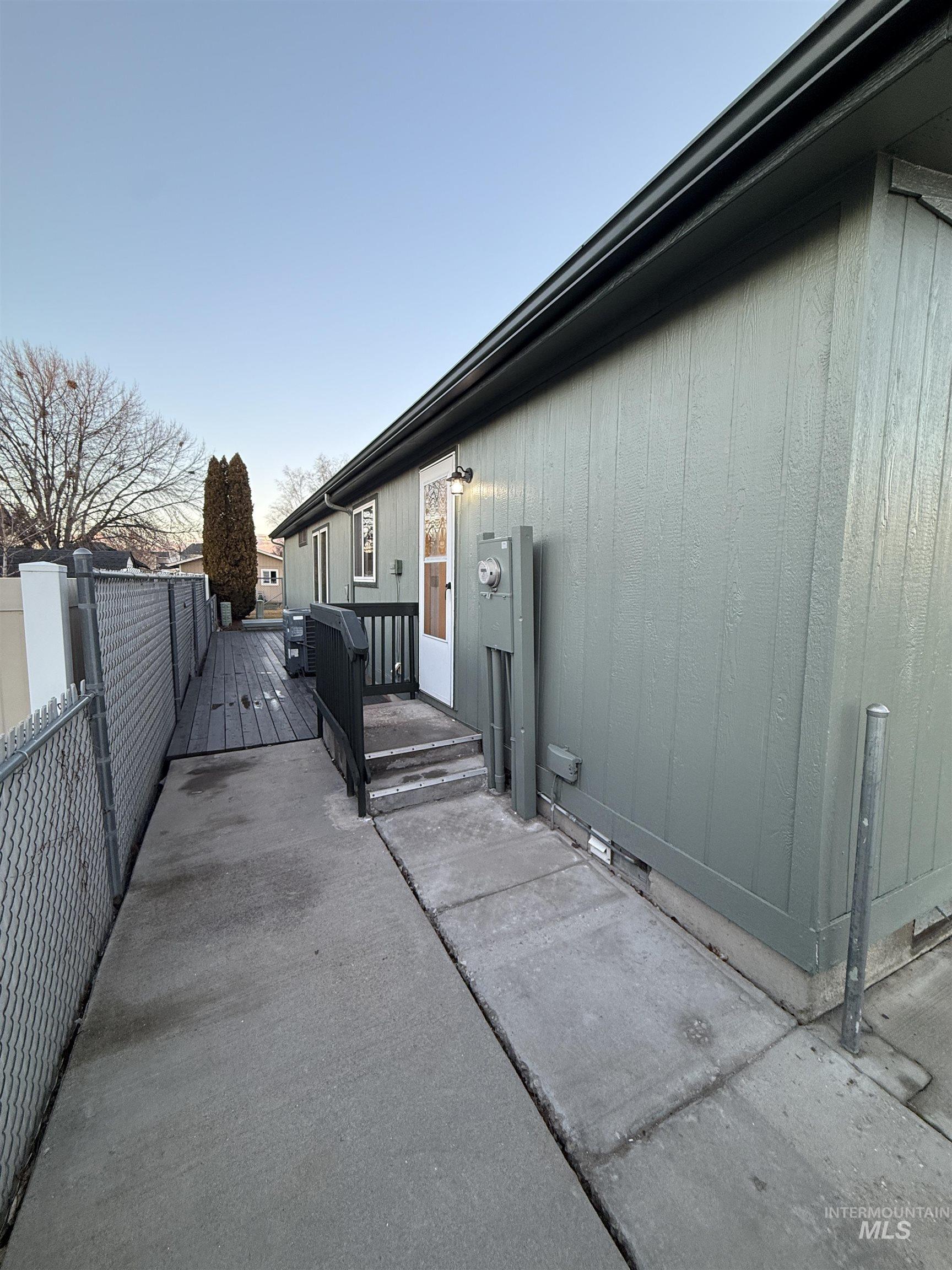 View of side of home with a wooden deck and crawl space