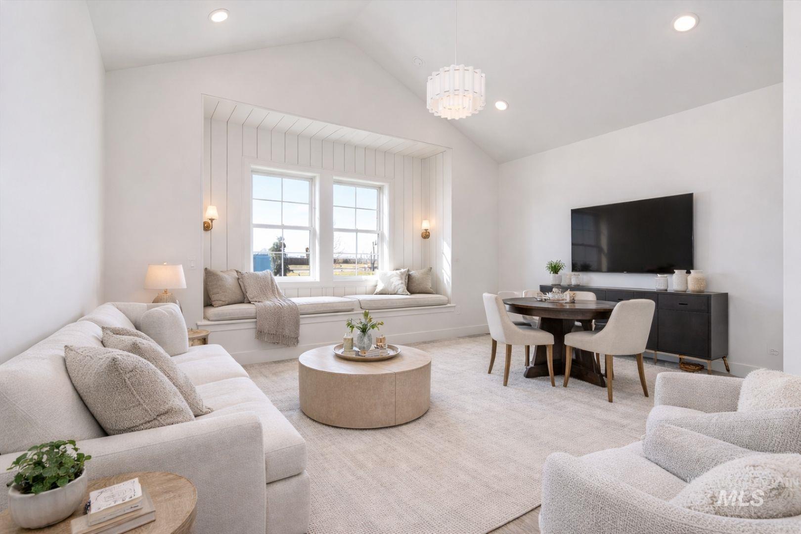 Vaulted ceiling great room featuring a window seat with built-in storage, recessed lighting, and wood-finish flooring