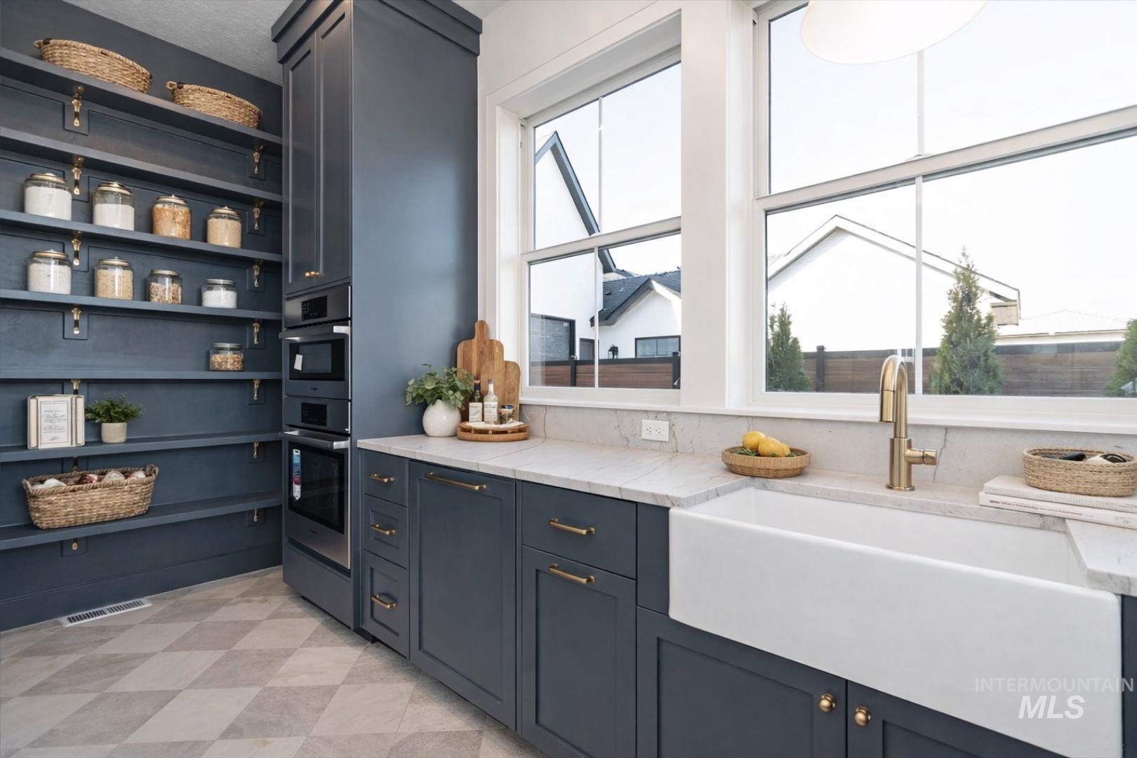 Custom cabinetry with integrated double ovens and open shelving