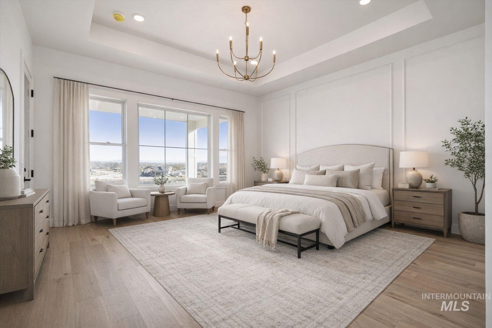 Spacious room featuring wide plank wood-finish flooring and a tray ceiling with recessed lighting