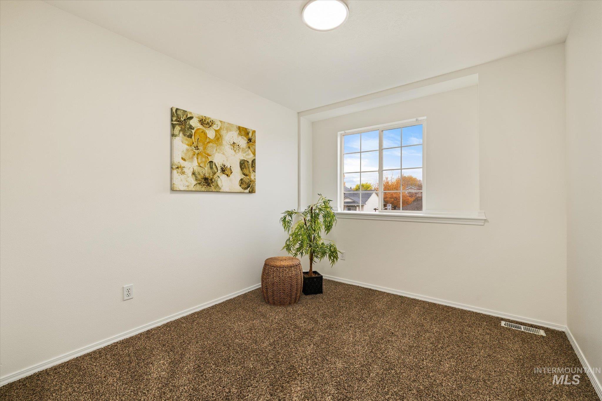 Carpeted empty room with baseboards