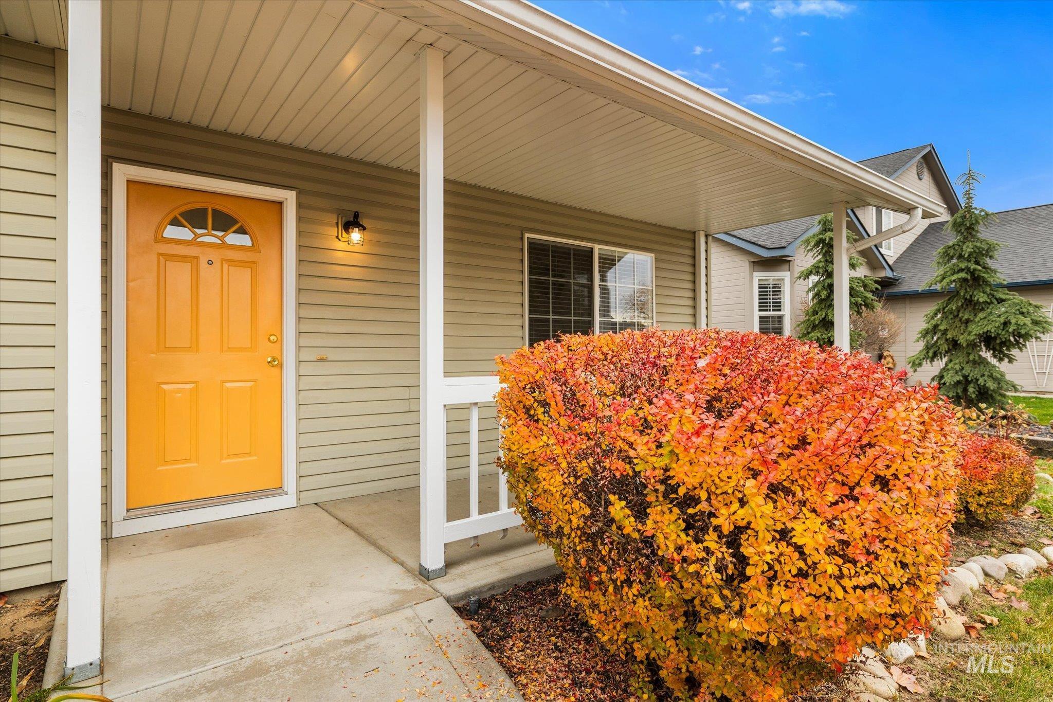 Doorway to property featuring covered porch and a shingled roof