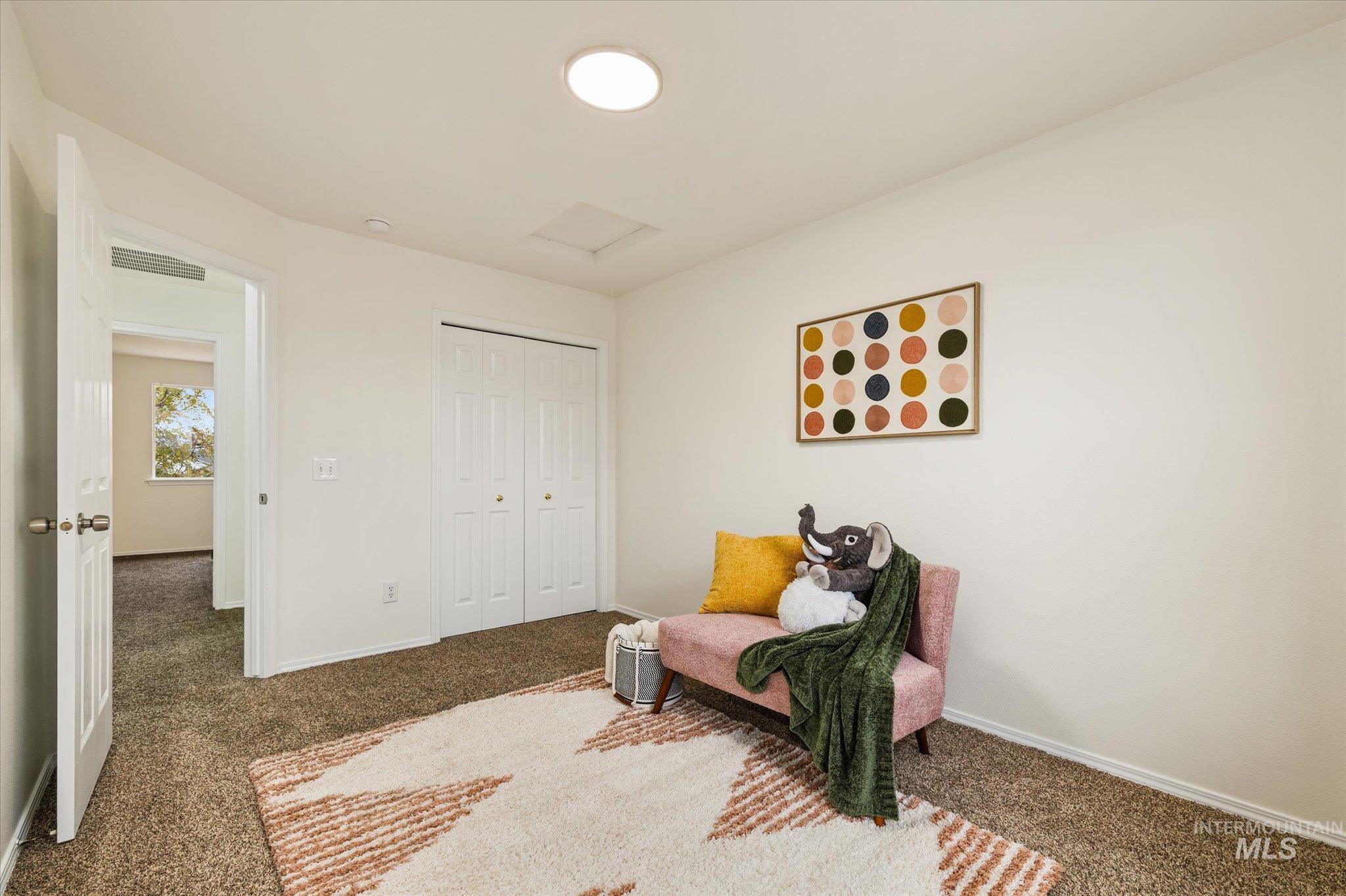 Living area with carpet flooring and attic access