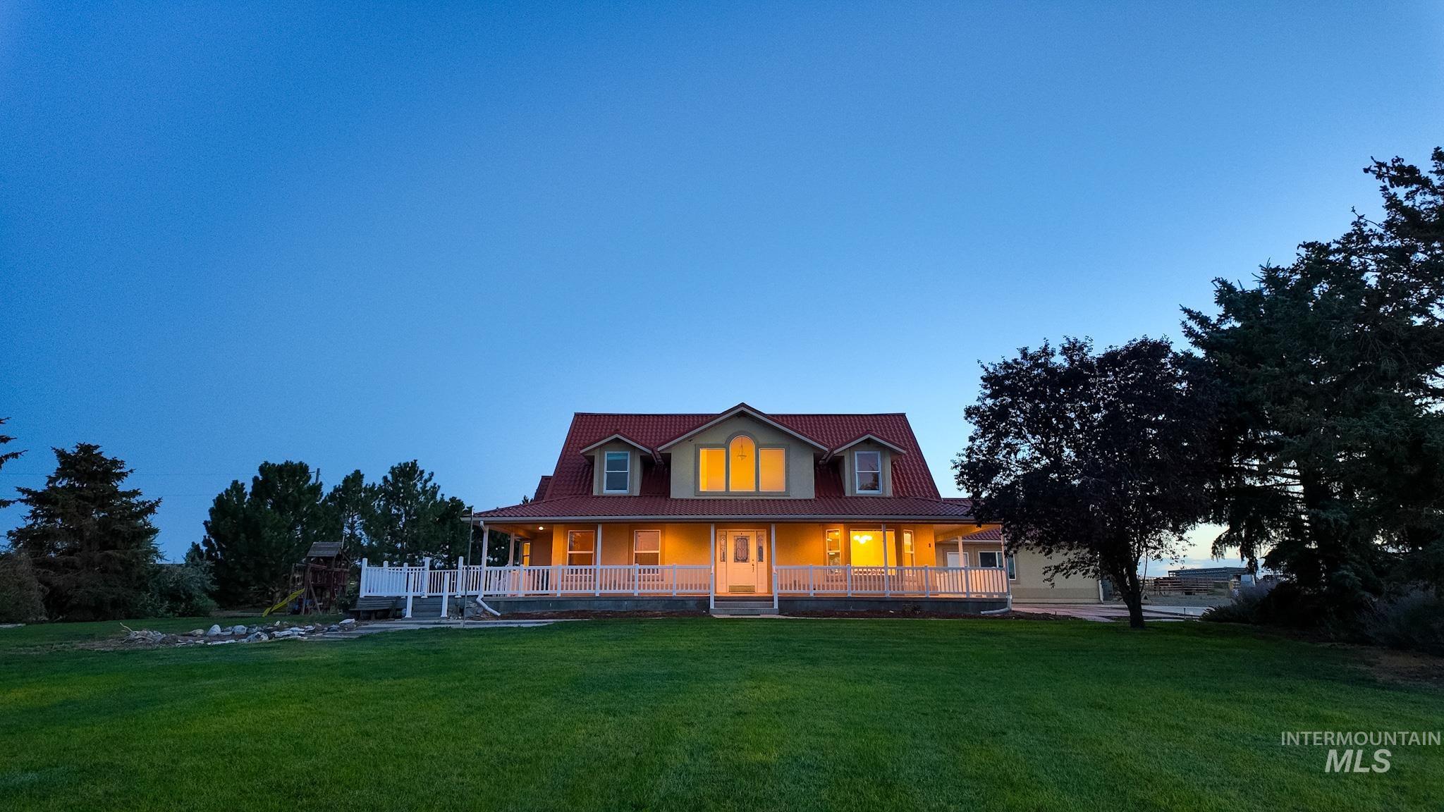 Farmhouse-style home featuring a large porch and a yard